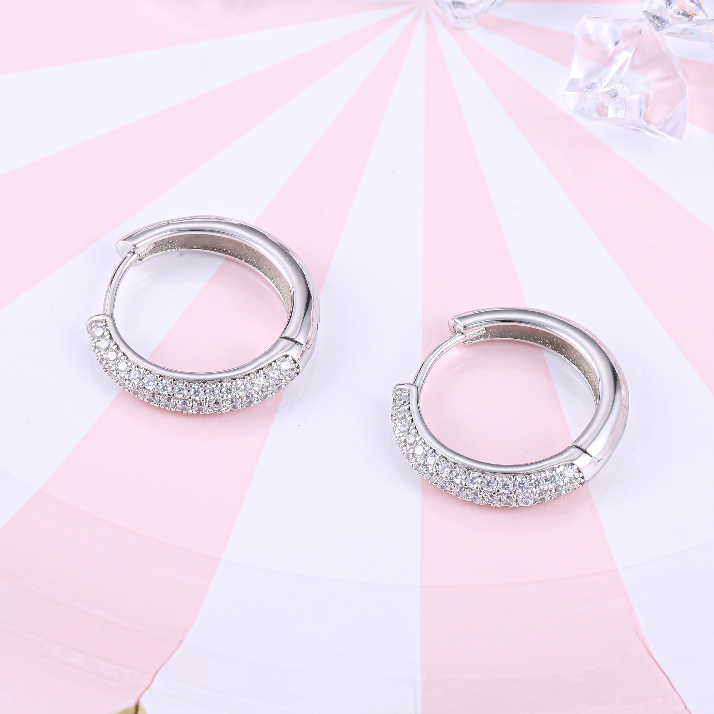 Elegant huggie hoop earrings for women made of 925 sterling silver with white sapphire accents.