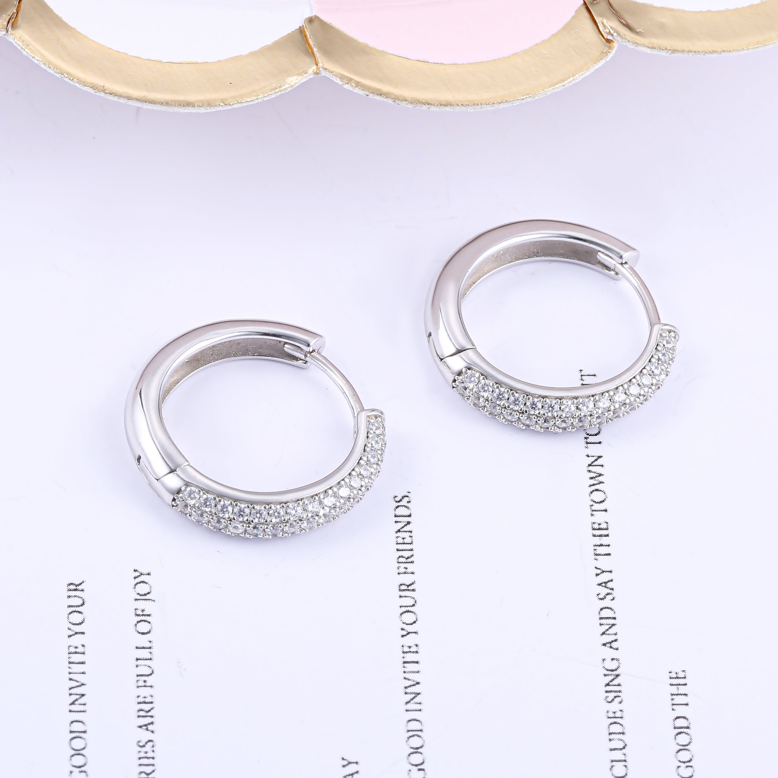 Elegant huggie hoop earrings for women made of 925 sterling silver with white sapphire accents.