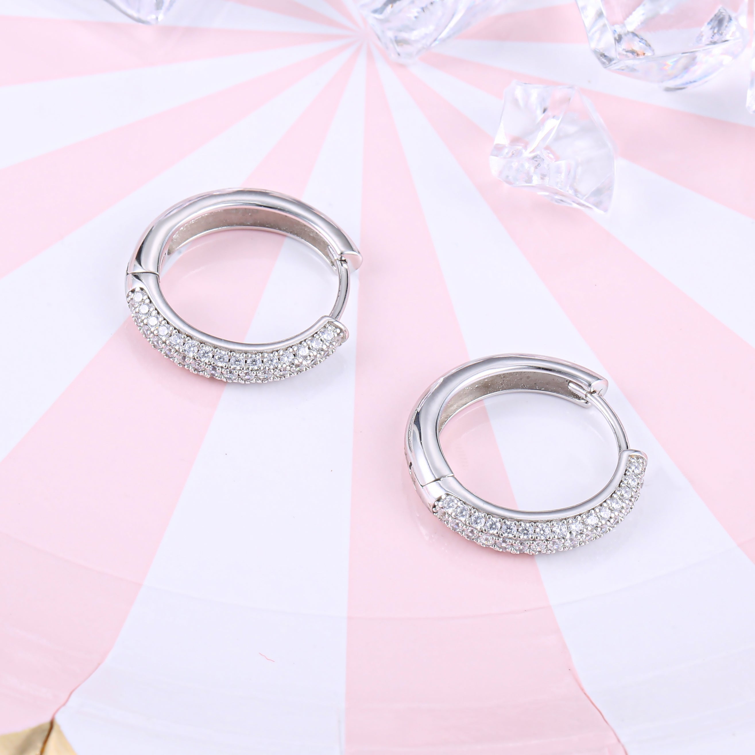 Elegant huggie hoop earrings for women made of 925 sterling silver with white sapphire accents.