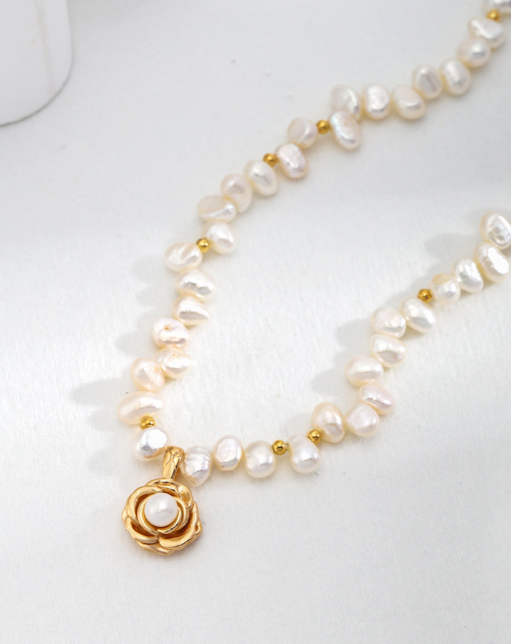 Ideal Love Pearl Necklace featuring a camellia pendant in antique gold, adorned with natural seawater pearls, showcasing elegance and romance.