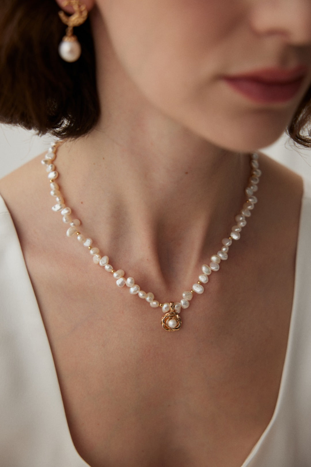 Ideal Love Pearl Necklace featuring a camellia pendant in antique gold, adorned with natural seawater pearls, showcasing elegance and romance.