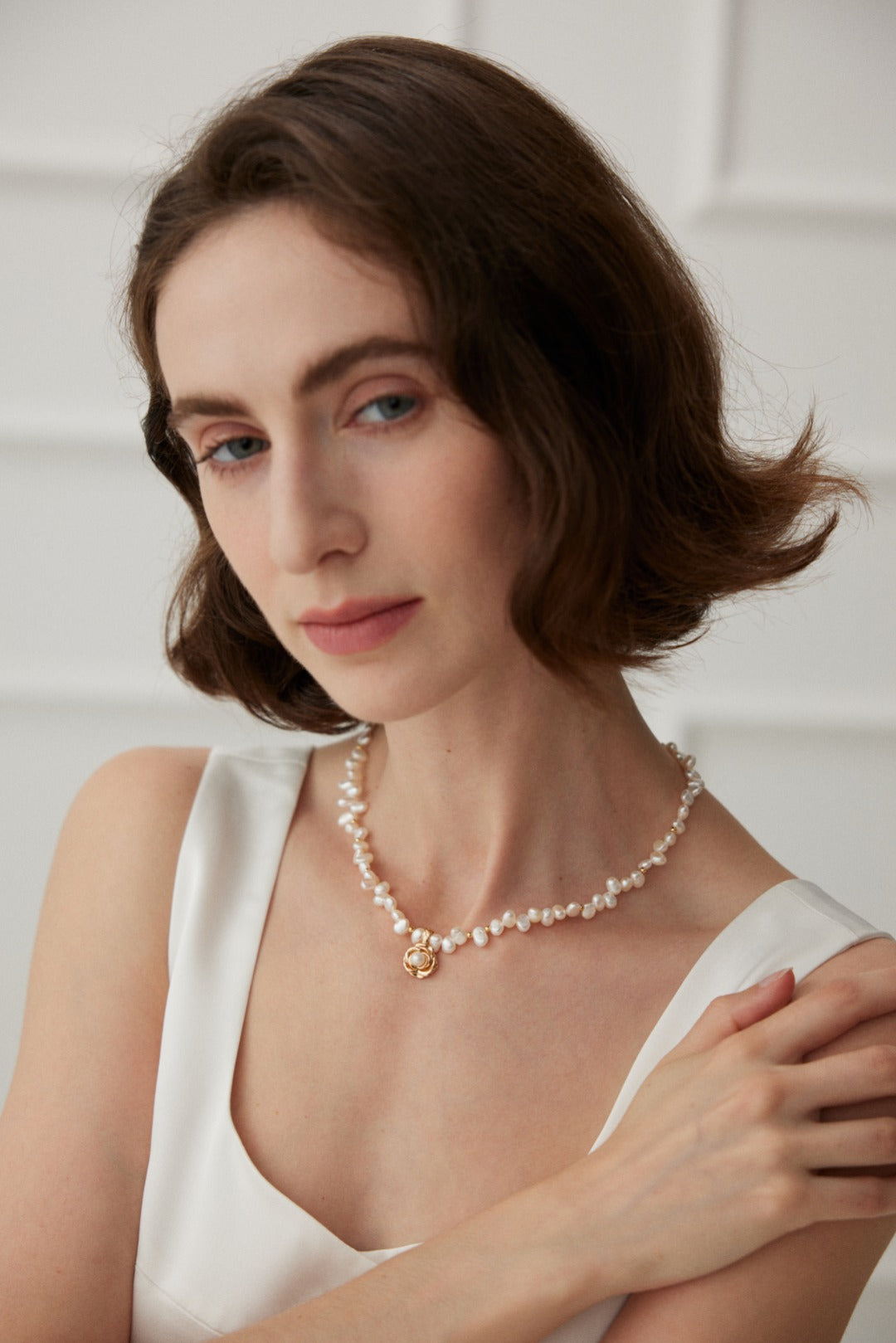 Ideal Love Pearl Necklace featuring a camellia pendant in antique gold, adorned with natural seawater pearls, showcasing elegance and romance.