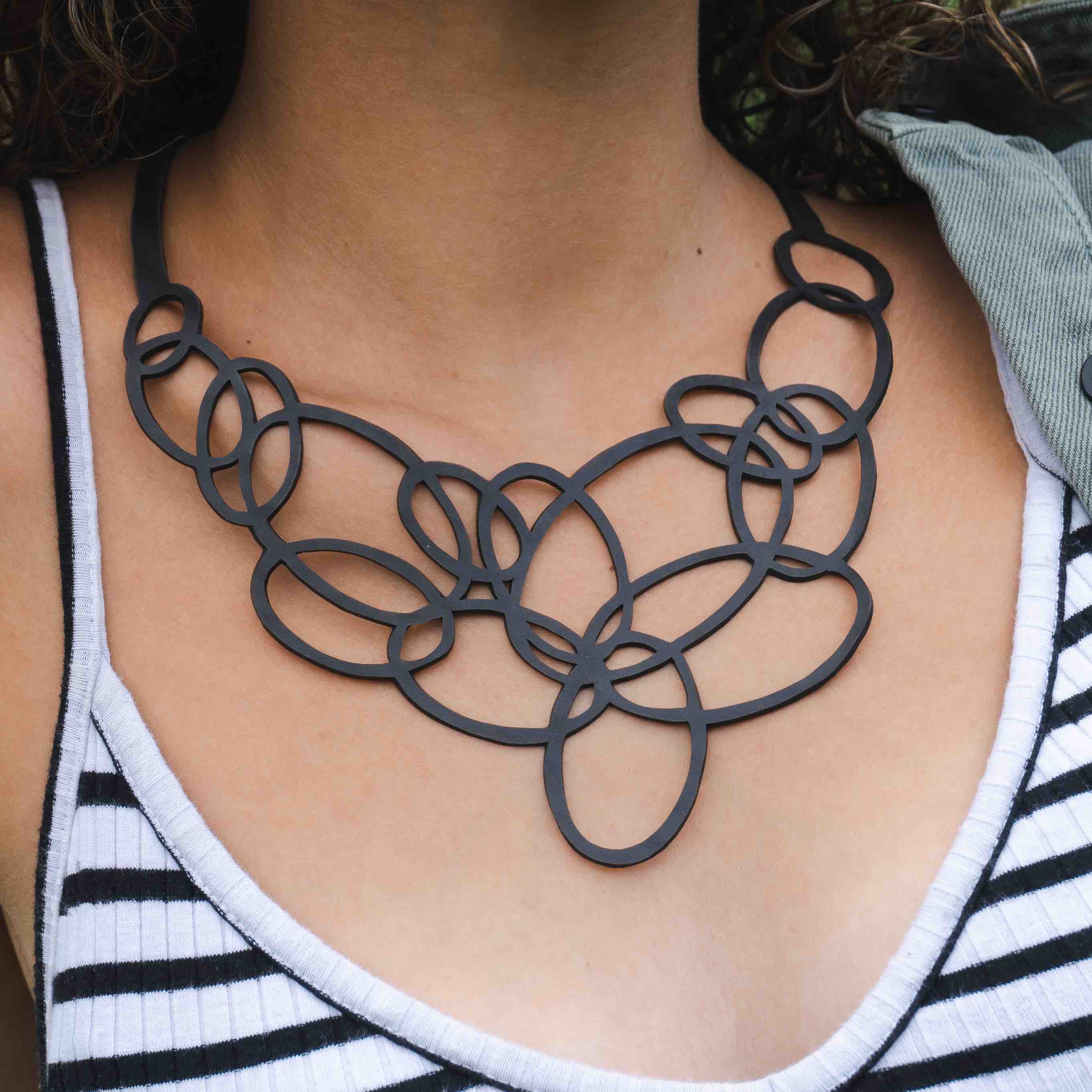 Elegant Infinity Upcycled Inner Tube Necklace made from reclaimed rubber, showcasing unique patterns and textures.