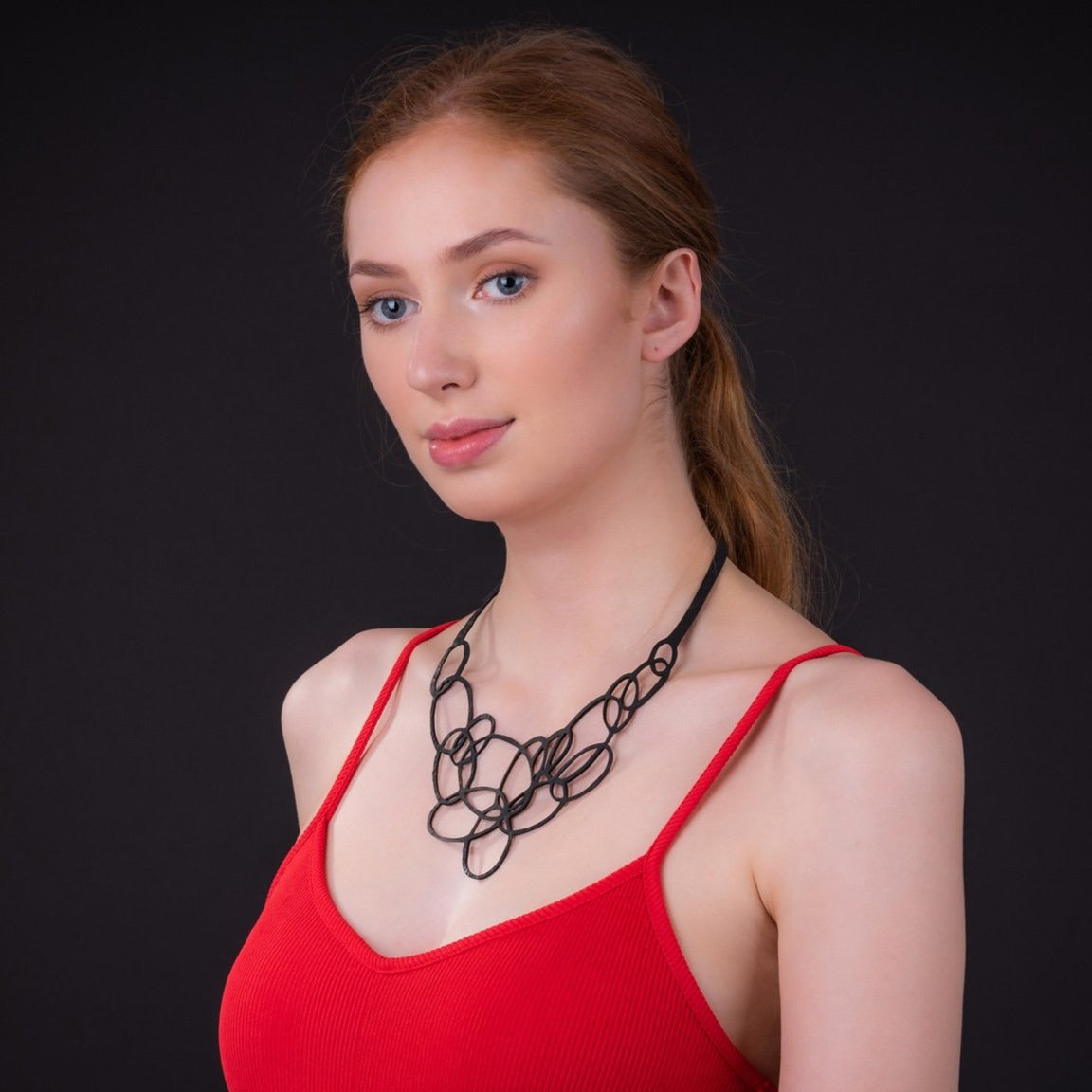 Elegant Infinity Upcycled Inner Tube Necklace made from reclaimed rubber, showcasing unique patterns and textures.