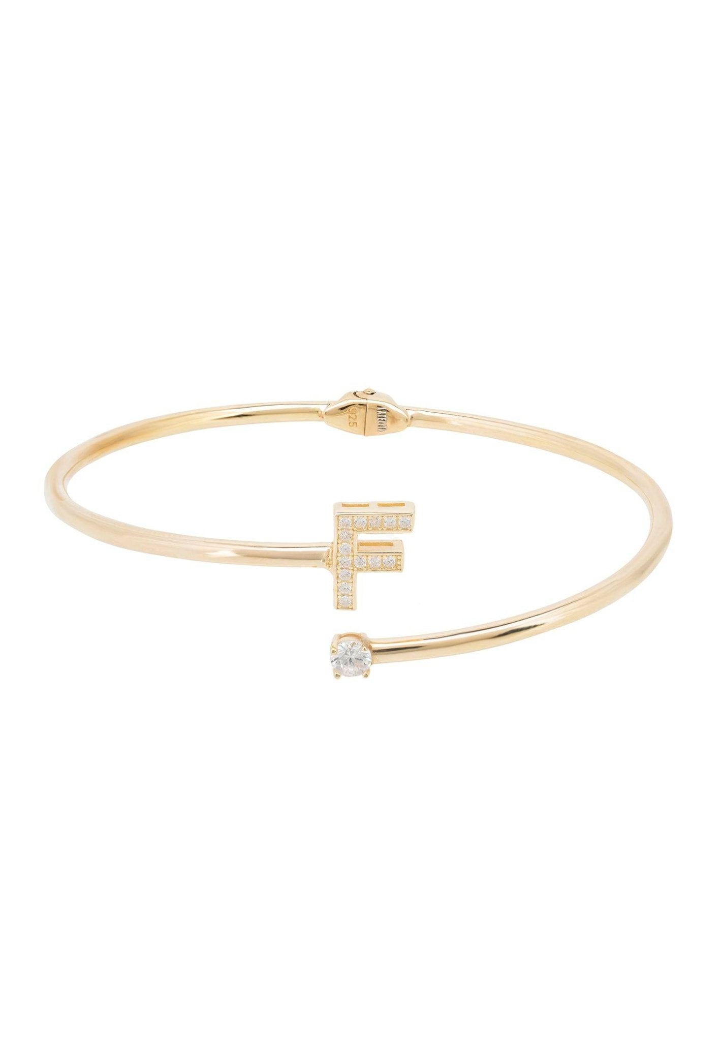 Gold bracelet with 'F' detail.