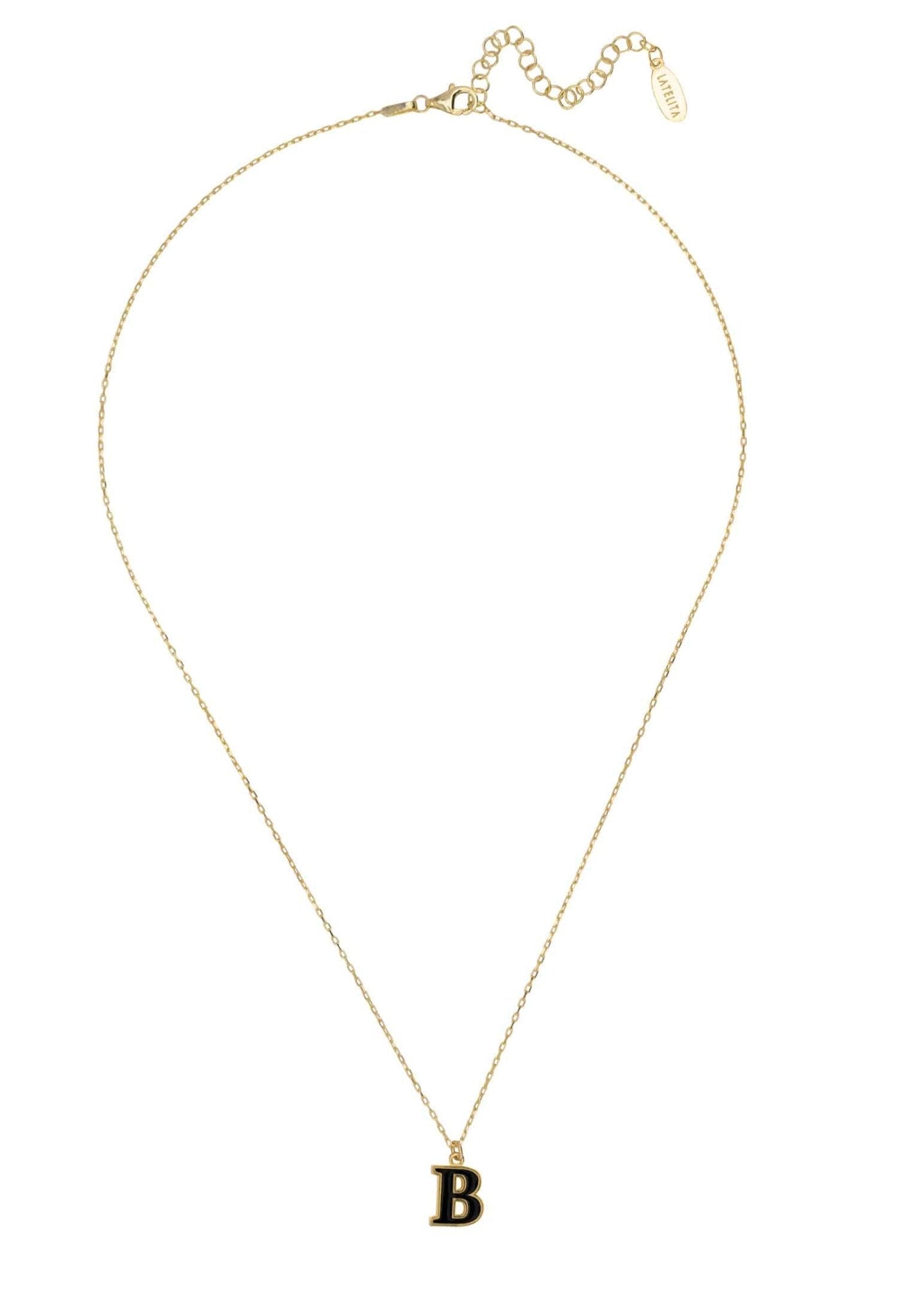 A delicate gold necklace featuring an initial pendant with black enamel inlay, elegantly displayed in a jewelry box.