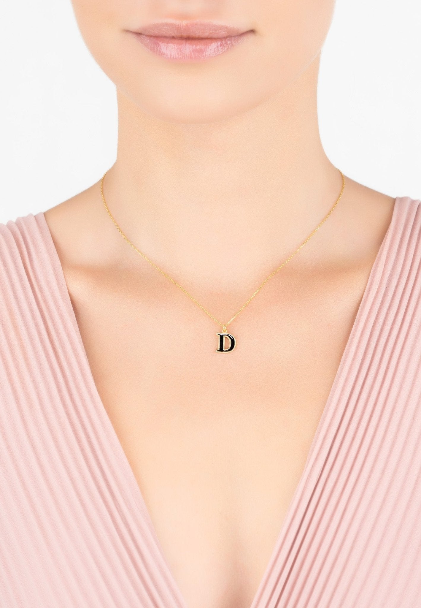 Initial Enamel Necklace Gold D featuring a delicate gold chain and black enamel pendant, elegantly displayed in a jewelry box.