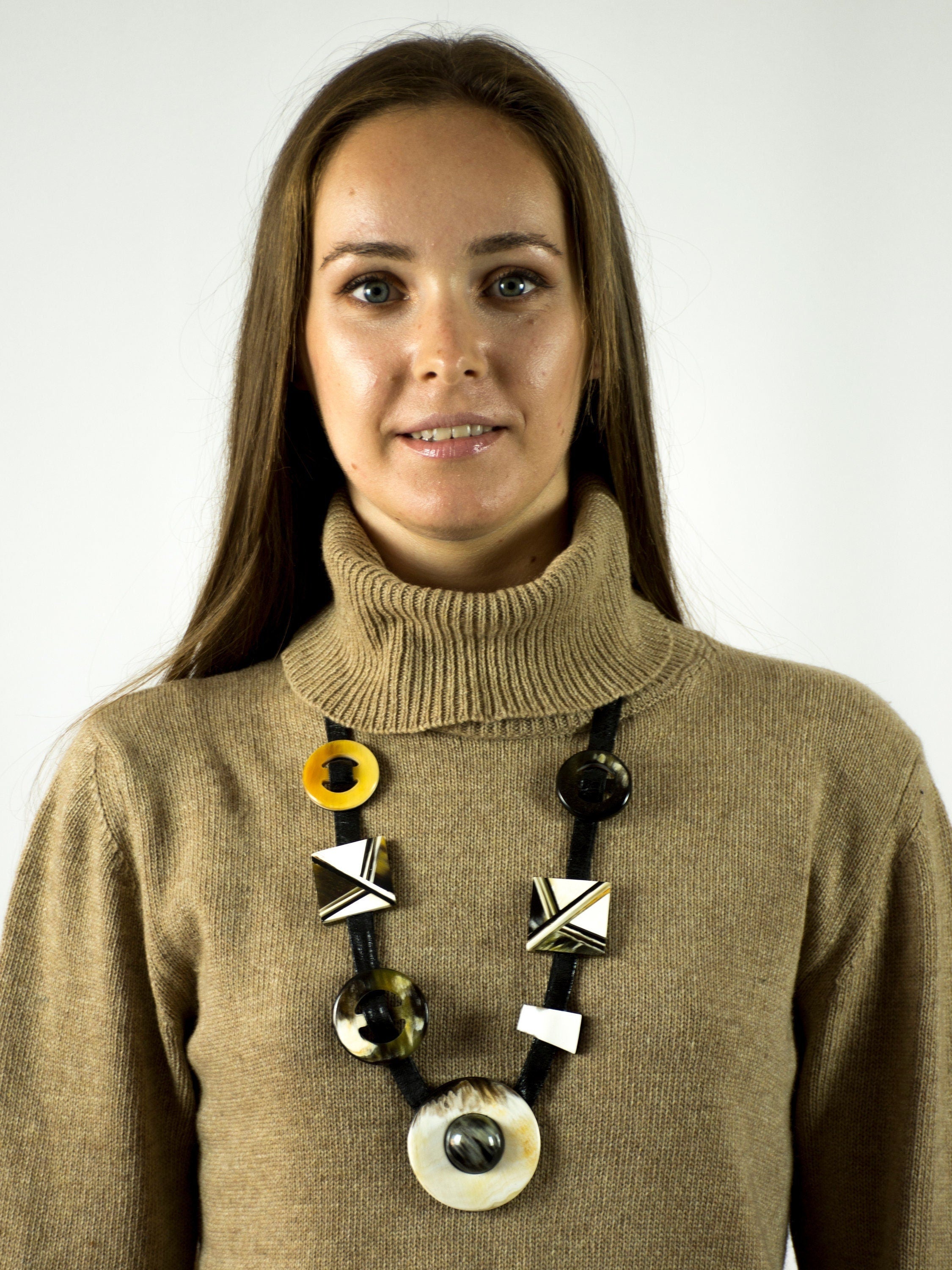 A beautifully crafted inlaid necklace made from natural buffalo horn, featuring a unique black and white design with a leather cord.