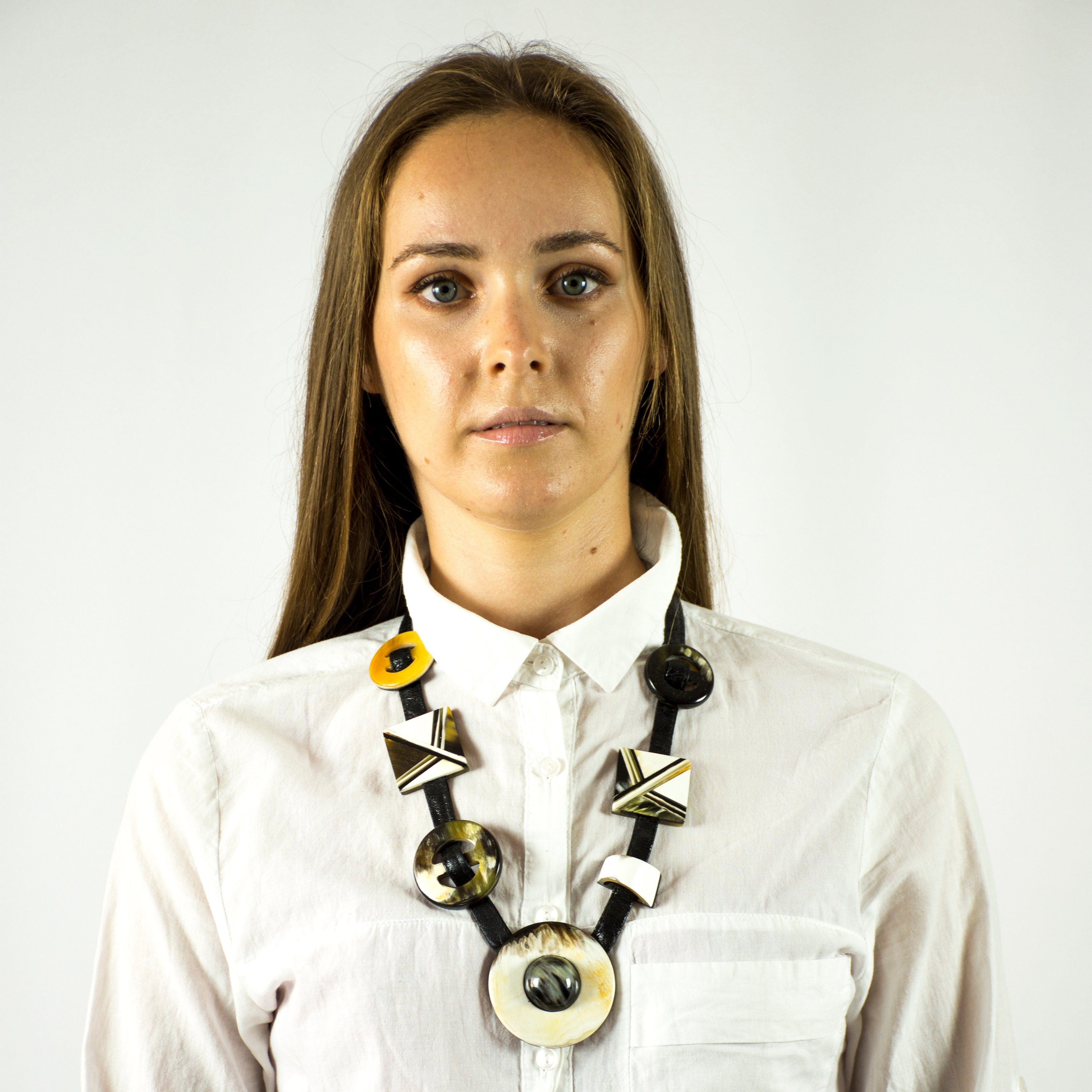 A beautifully crafted inlaid necklace made from natural buffalo horn, featuring a unique black and white design with a leather cord.