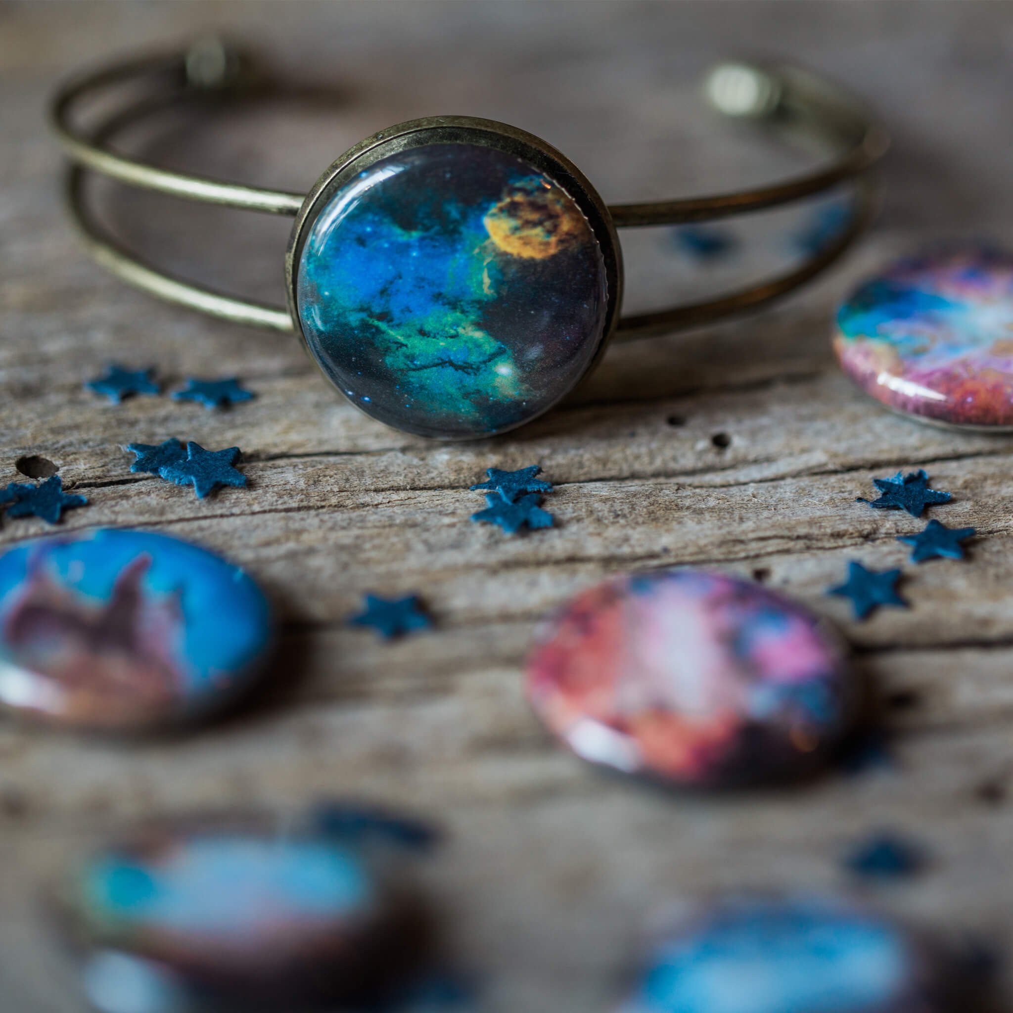 Interchangeable Nebula Cuff Bracelet featuring ten unique nebula designs in antique bronze and silver-tone, showcasing its magnetic clasp and adjustable fit.