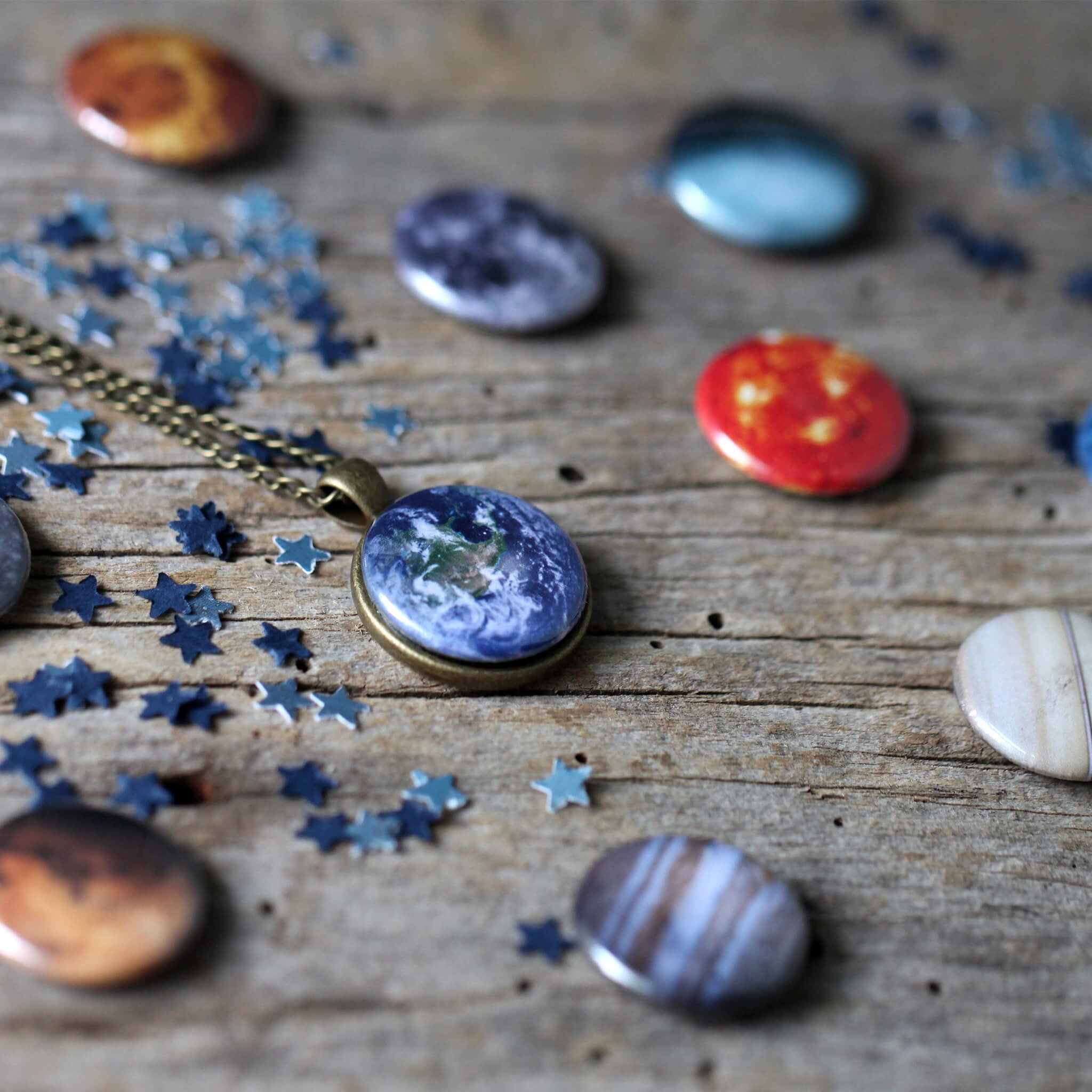 Interchangeable Solar System Necklace featuring 8 planets, the Moon, and the Sun on a silver or bronze chain, showcasing a unique travel jewelry design.