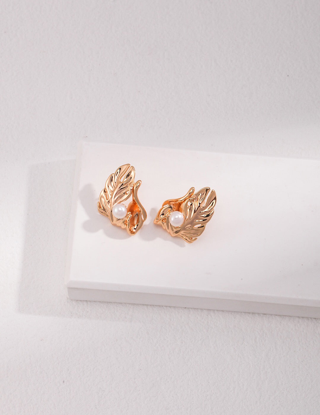 A pair of handmade Irregular Leaf Pearl Earrings featuring natural pearls and gold vermeil, showcasing an elegant leaf design.