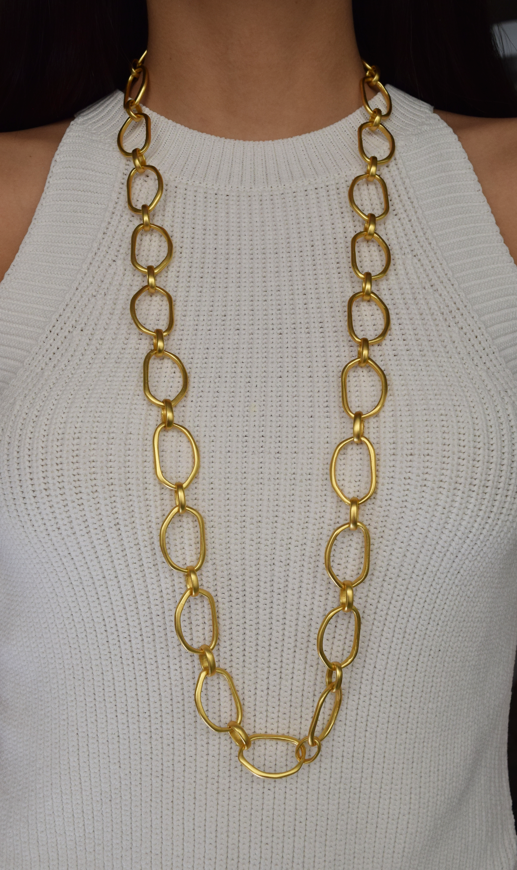 Irregular Link Long Chain necklace featuring polished gold cut-out links, elegantly displayed against a neutral background.