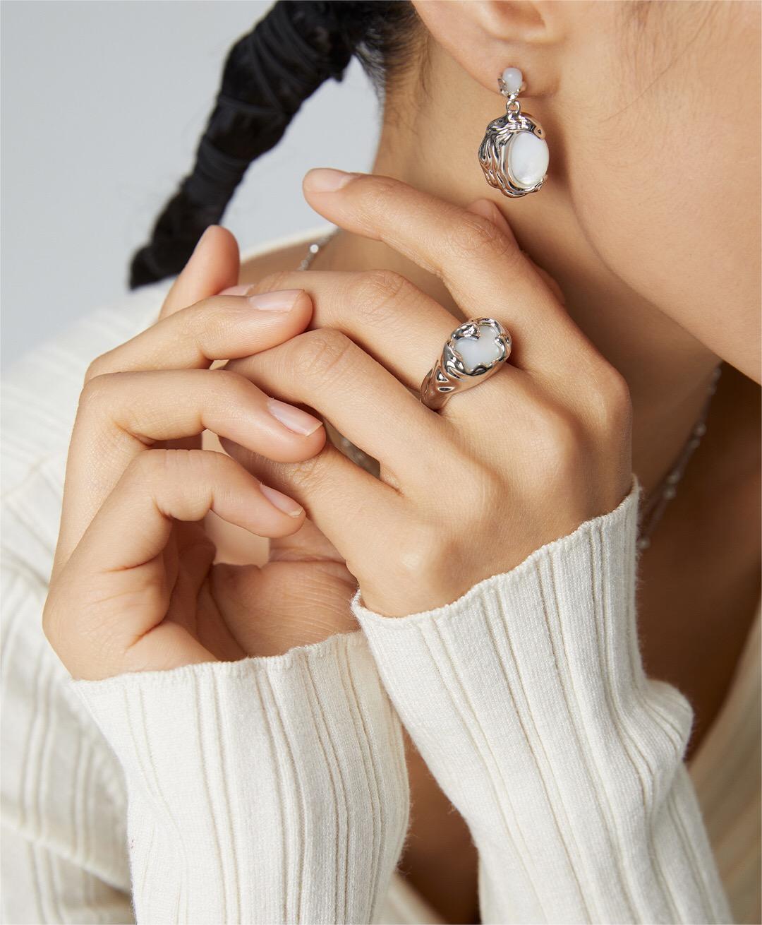 A handmade irregular texture mother-of-pearl ring featuring sterling silver and gold vermeil, showcasing its unique design and iridescent finish.