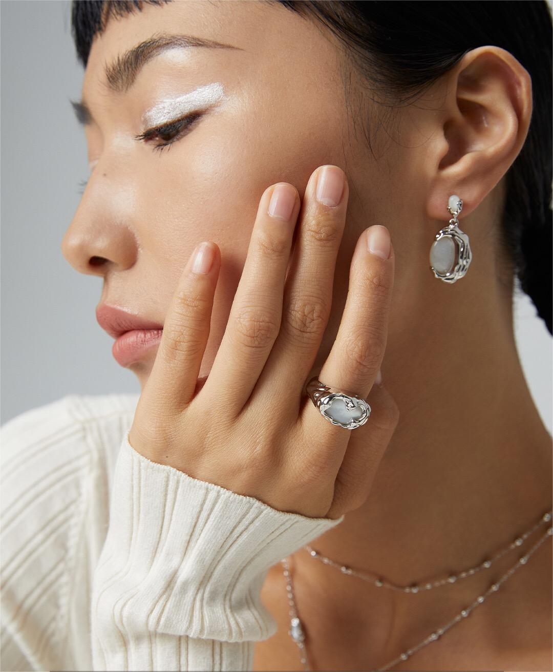 A handmade irregular texture mother-of-pearl ring featuring sterling silver and gold vermeil, showcasing its unique design and iridescent finish.