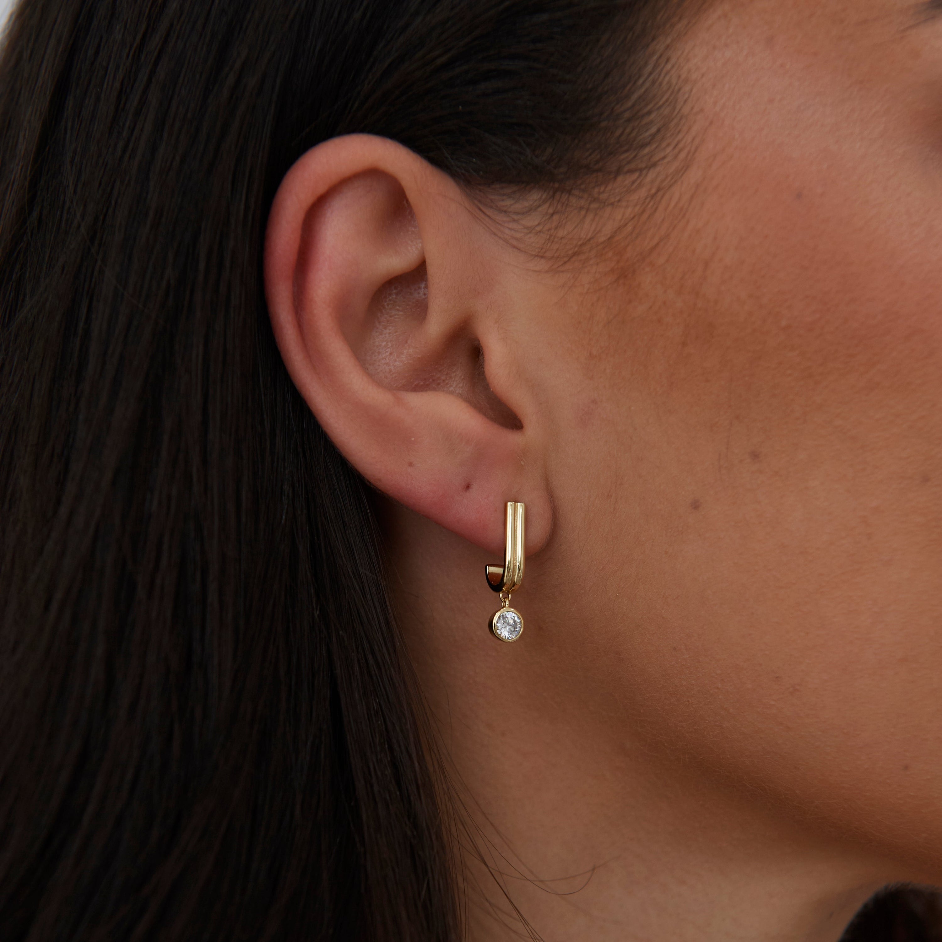 Iris CZ Earring featuring a half-inch drop design with a sparkling cubic zirconia stone and 18k gold plating.