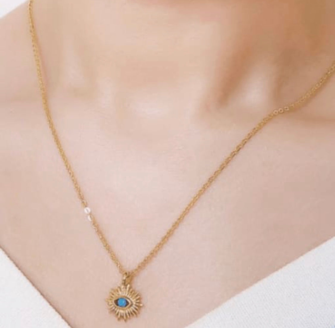 IRIS Necklace featuring an evil eye design with sun rays and a cubic zirconia stone, elegantly plated in 18K gold.