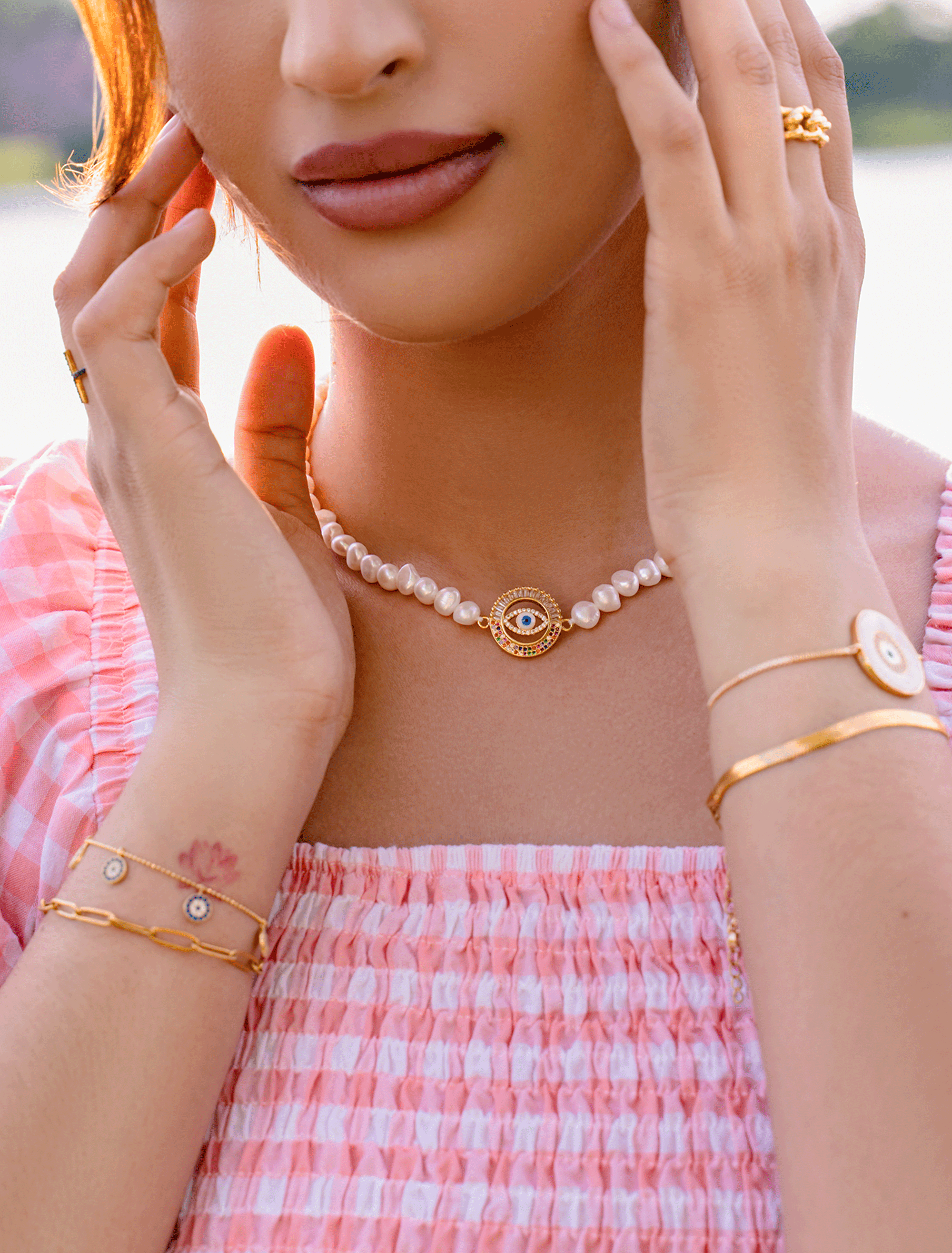 Elegant IVY Necklace featuring a filigree evil eye pendant with vibrant stones and a freshwater pearl strand.