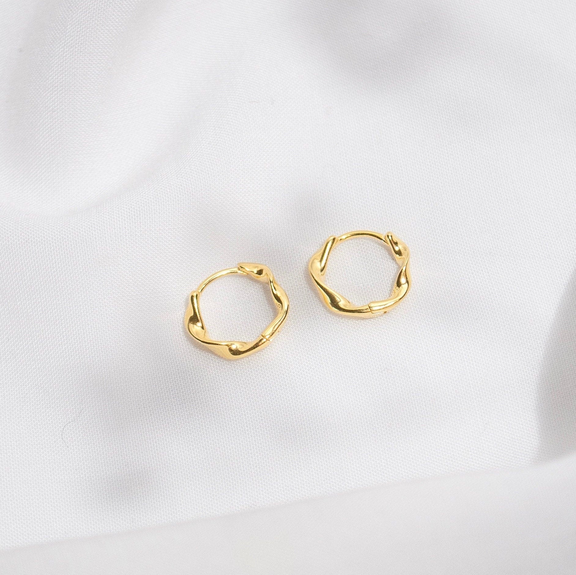 Jana twisted hoop earrings in gold and silver, showcasing a luxurious twisted design.