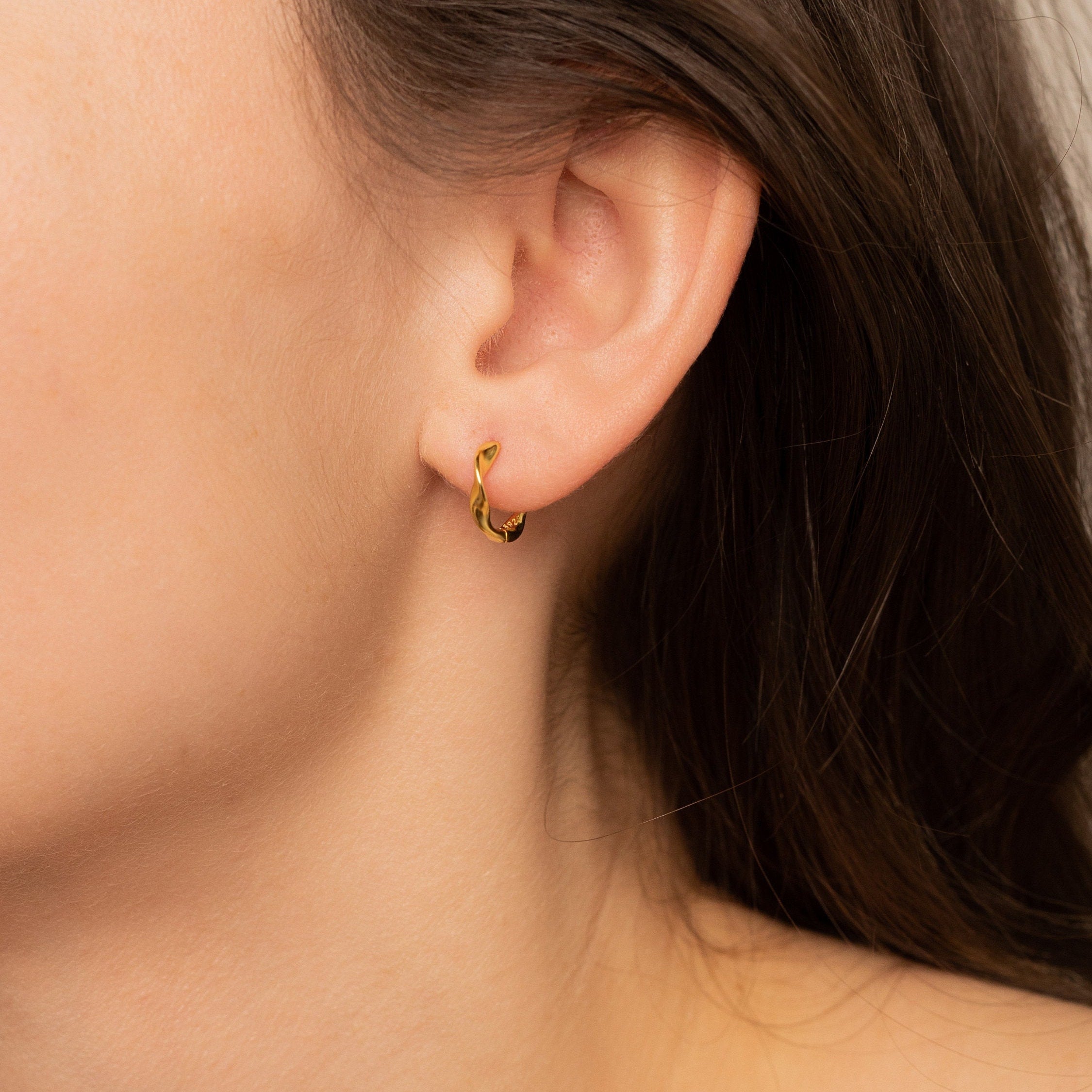 Jana twisted hoop earrings in gold and silver, showcasing a luxurious twisted design.