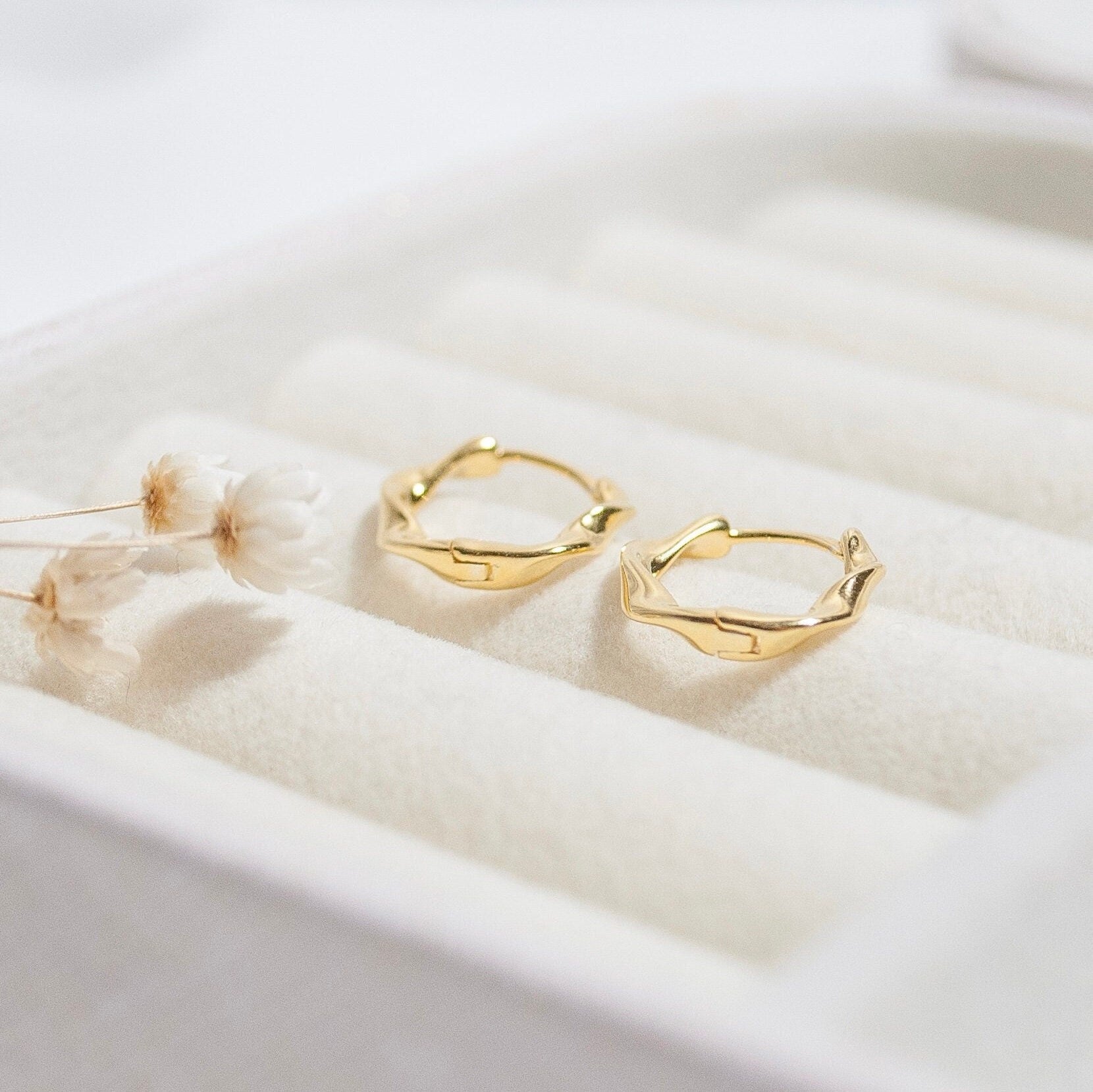 Jana twisted hoop earrings in gold and silver, showcasing a luxurious twisted design.