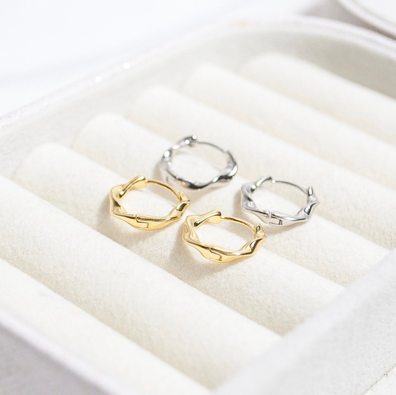 Jana twisted hoop earrings in gold and silver, showcasing a luxurious twisted design.