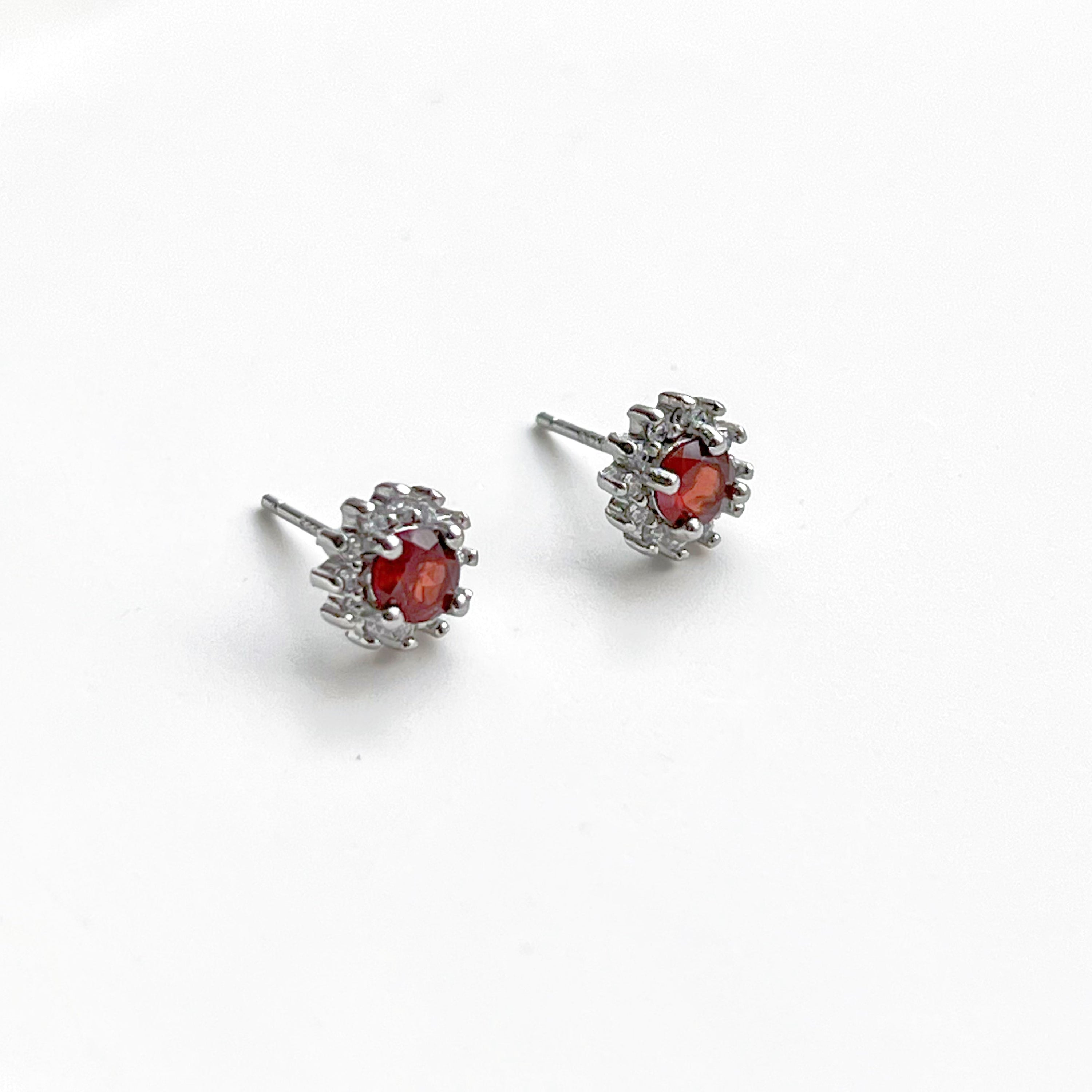 A pair of elegant garnet silver stud earrings featuring natural red garnet stones set in hypoallergenic sterling silver.