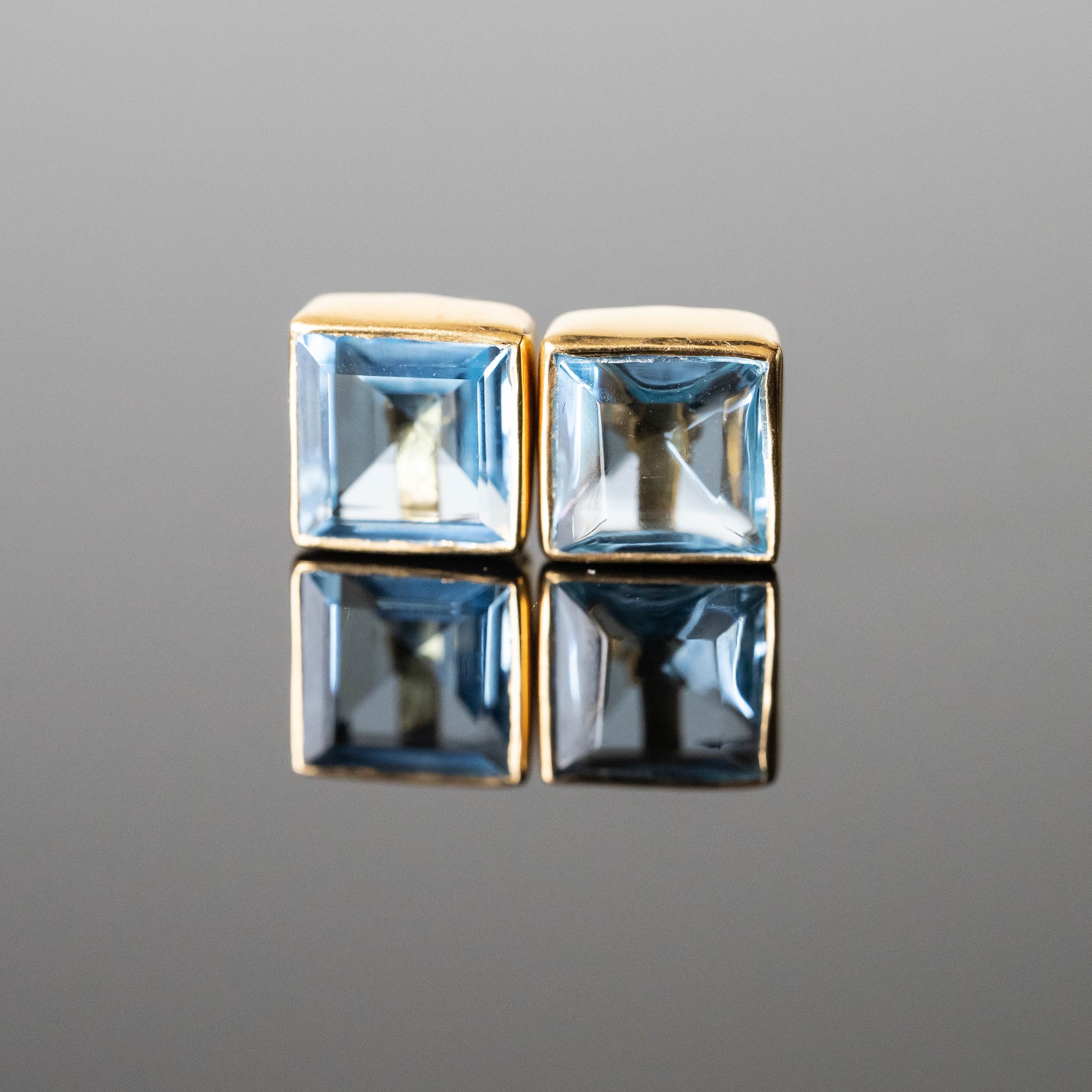 A pair of Jasmine Topaz Square Studs featuring Swiss blue topaz stones set in gold-plated 925 sterling silver, elegantly displayed.