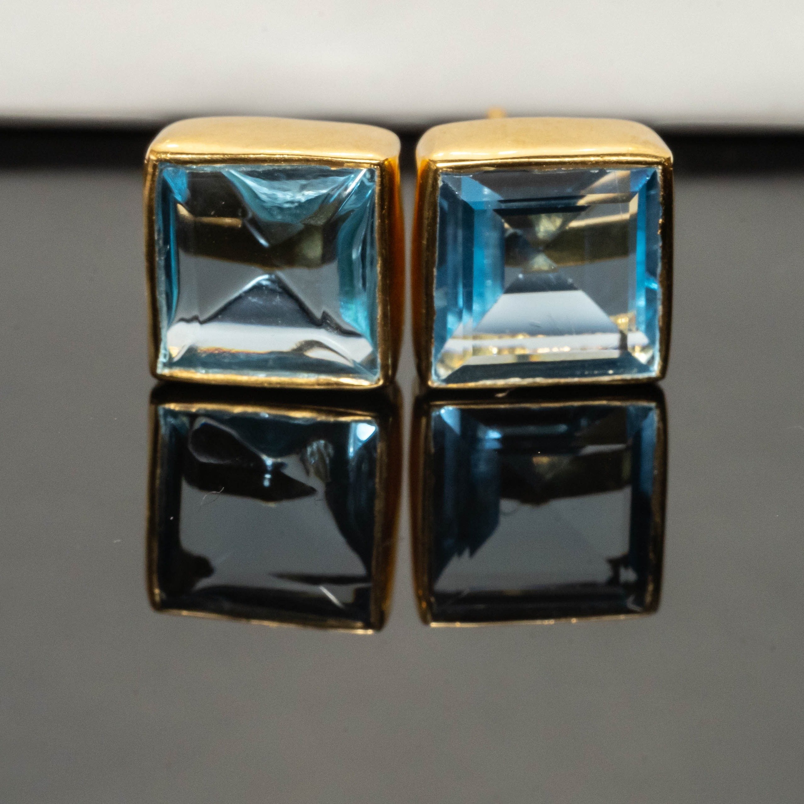 A pair of Jasmine Topaz Square Studs featuring Swiss blue topaz stones set in gold-plated 925 sterling silver, elegantly displayed.