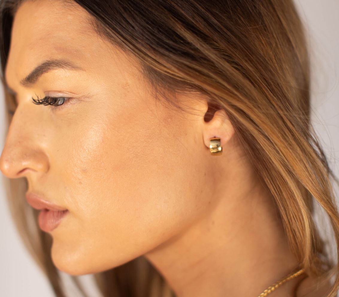 A pair of Jax Huggies earrings, 15mm mini huggies made from 18k gold plated stainless steel, showcasing a sleek and modern design.