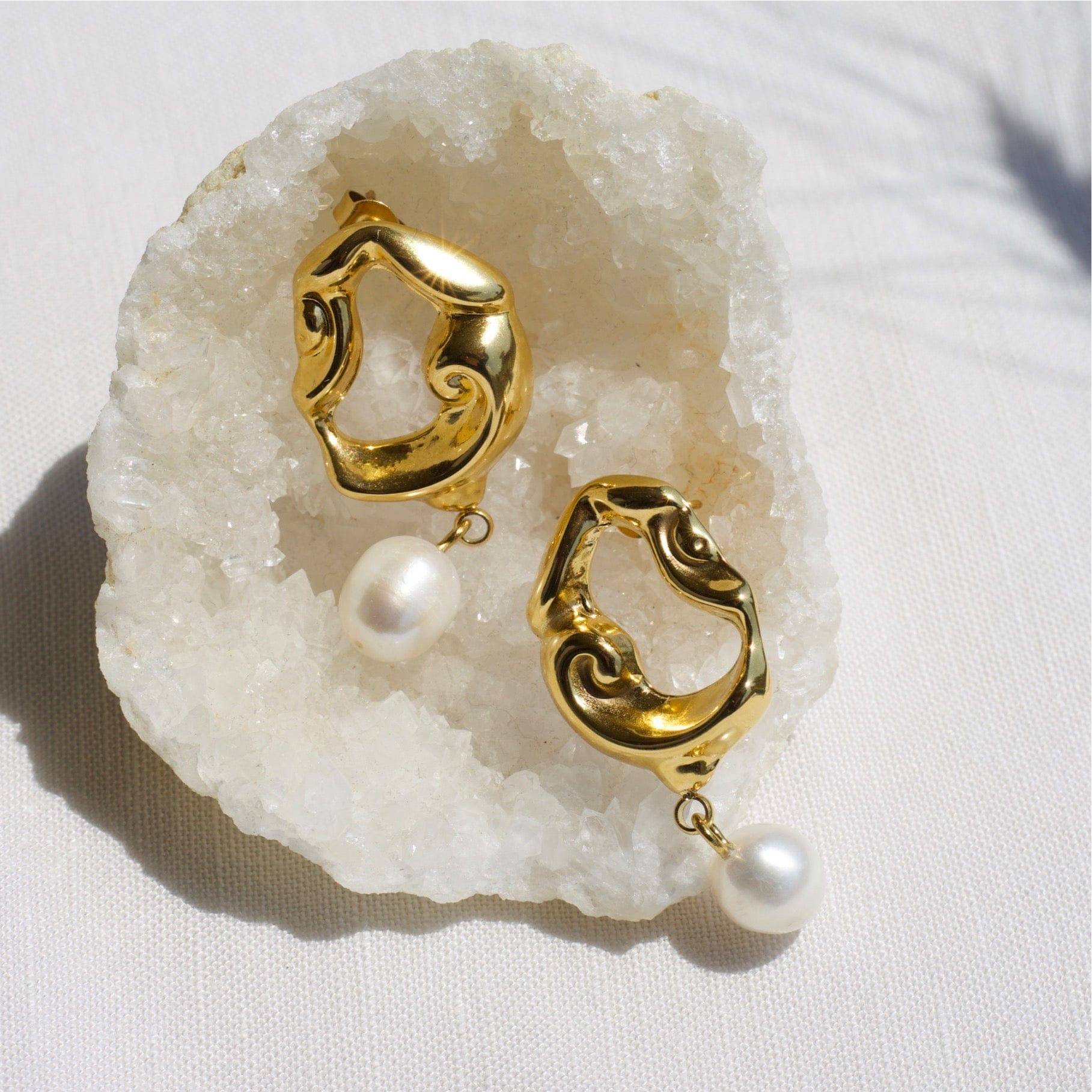 Jove gold hoops featuring baroque studs and dangling freshwater pearl drops, elegantly designed for a whimsical look.