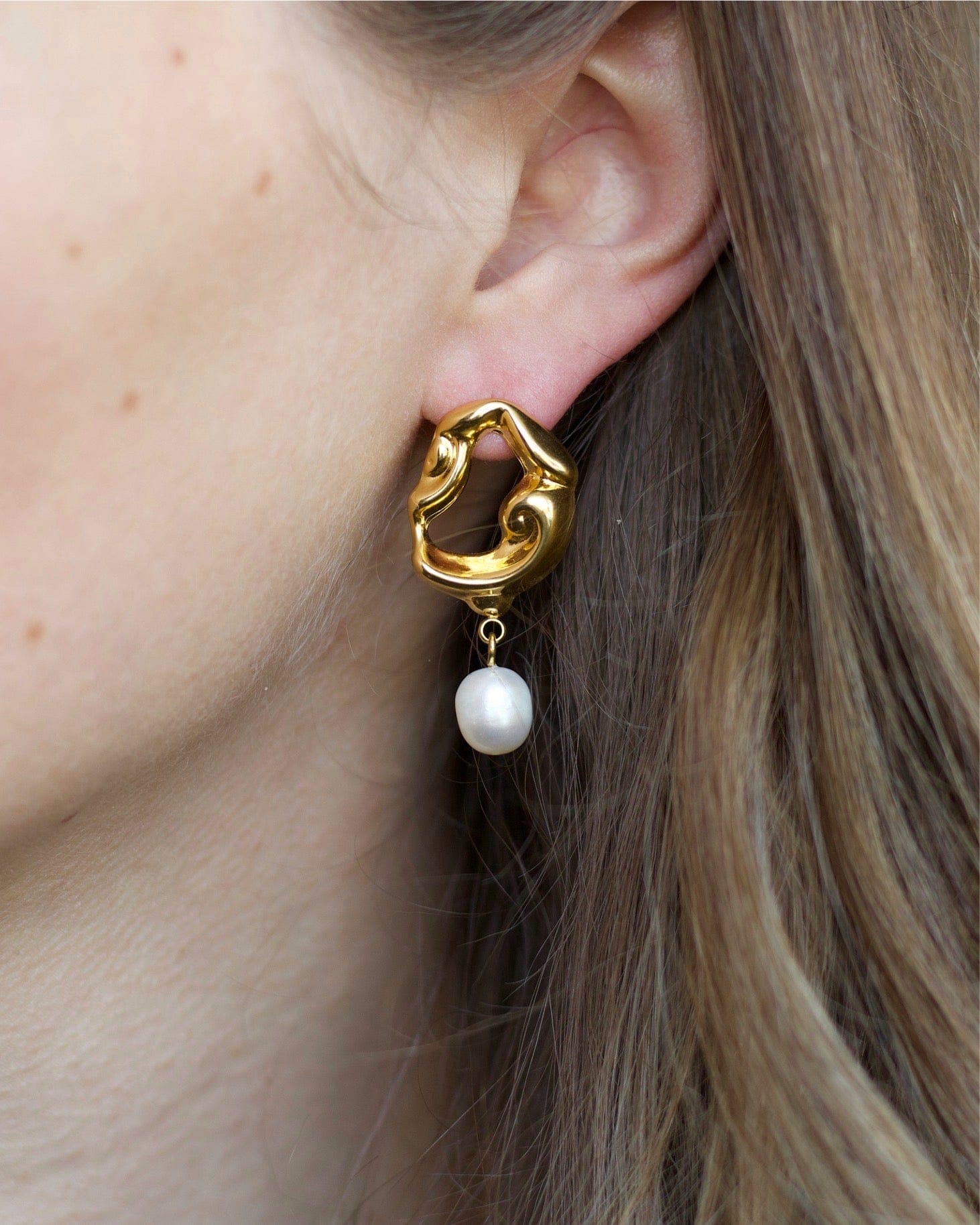 Jove gold hoops featuring baroque studs and dangling freshwater pearl drops, elegantly designed for a whimsical look.