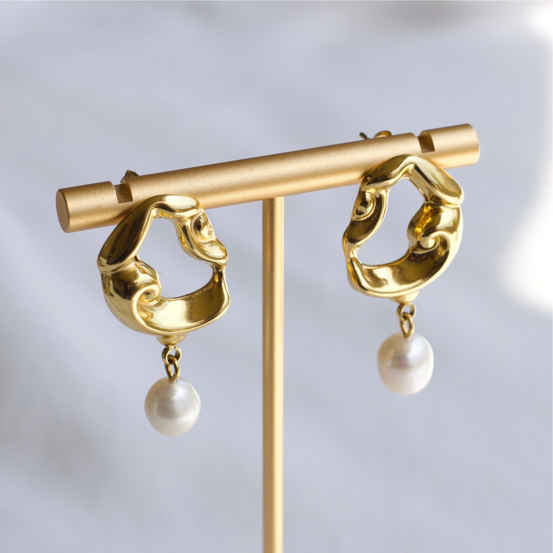 Jove gold hoops featuring baroque studs and dangling freshwater pearl drops, elegantly designed for a whimsical look.