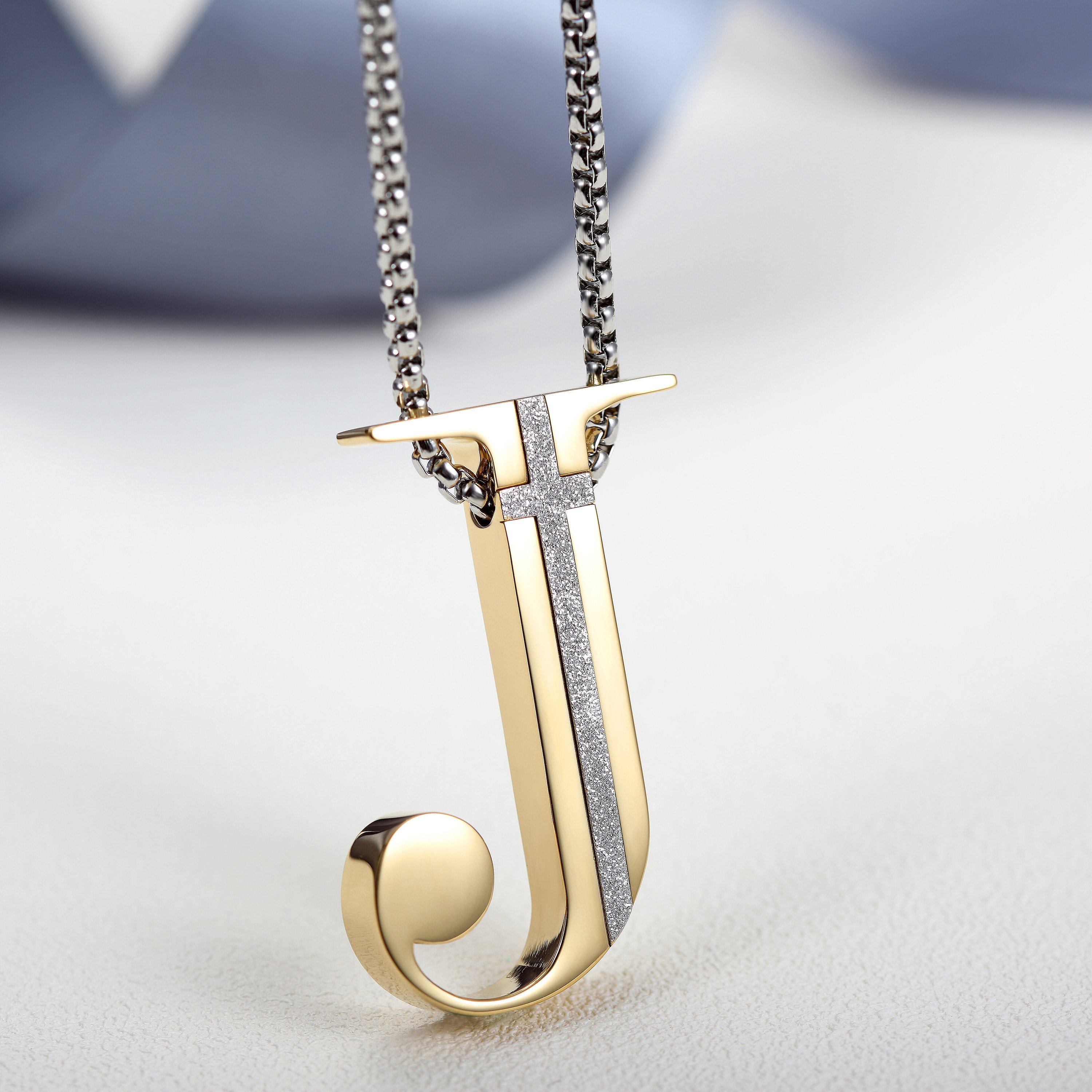 Elegant J-shaped pendant necklace made of 316L surgical stainless steel with 14K gold PVD plating.