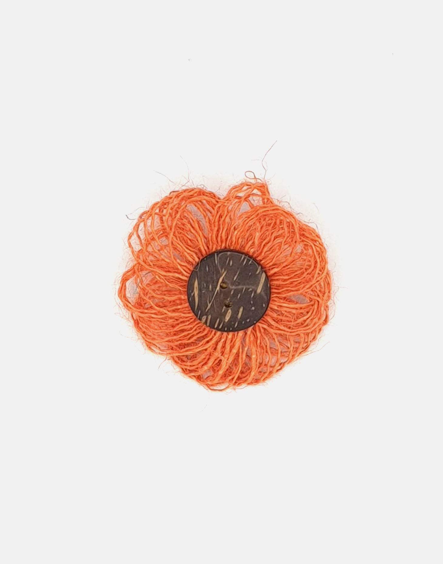 A delicate jute flower brooch featuring a coconut button at the center, showcasing natural fibers and a charming design.