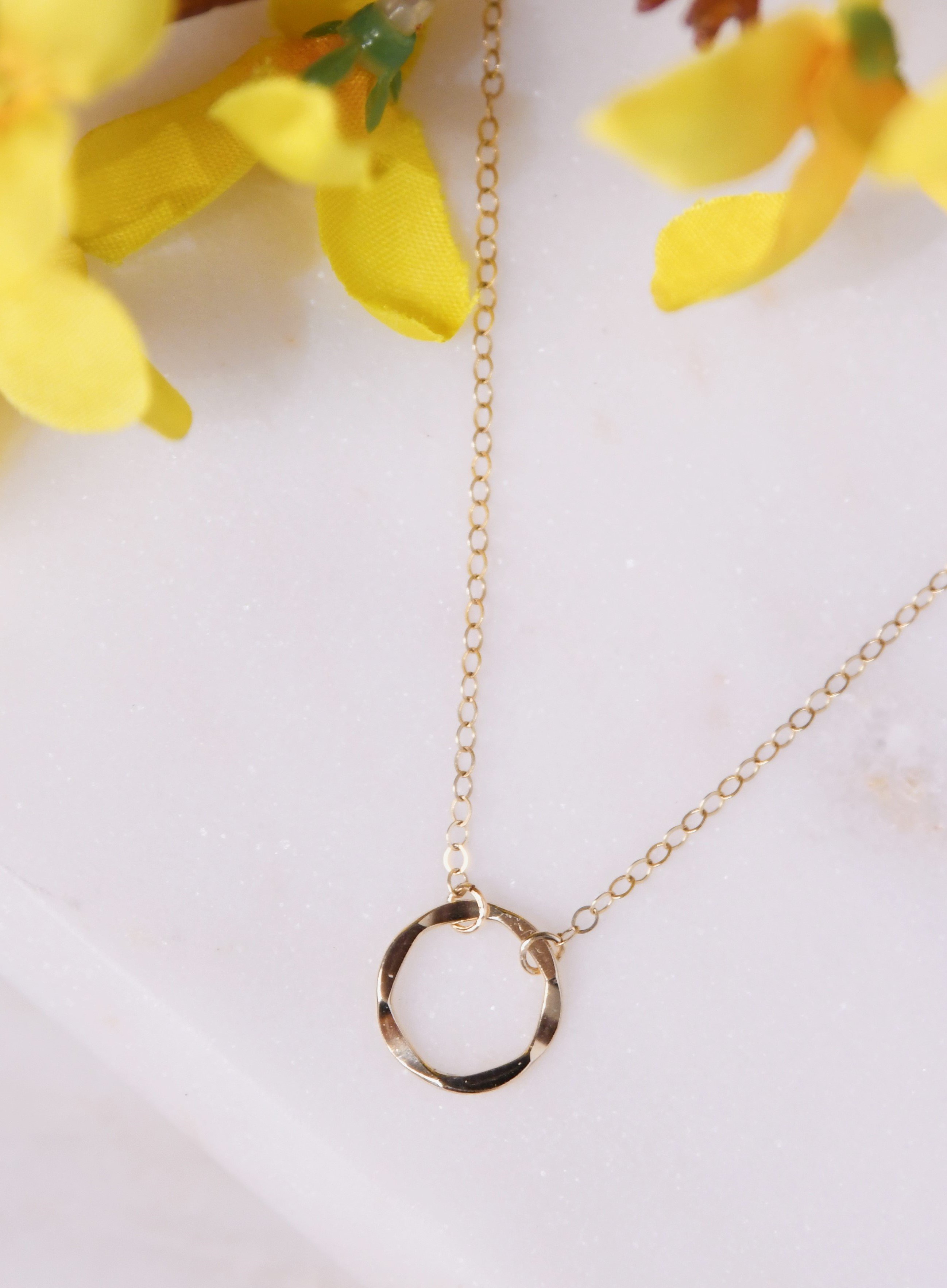 Karma Necklace featuring a hammered circle pendant on a gold or silver chain, symbolizing positivity and interconnectedness.