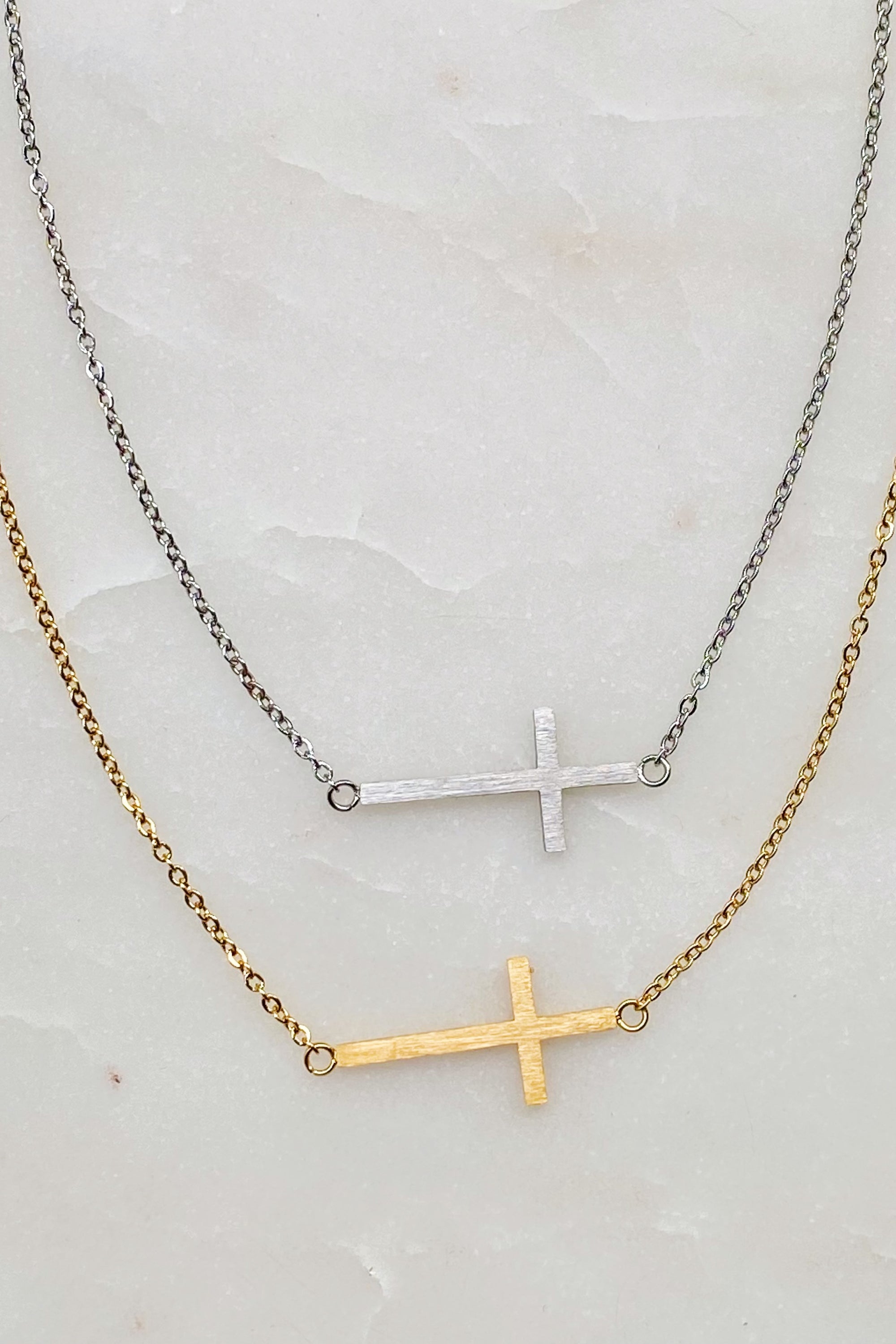 Kayla Cross Necklace featuring a side hanging cross design on a 16-inch chain, elegantly plated in 18K gold.