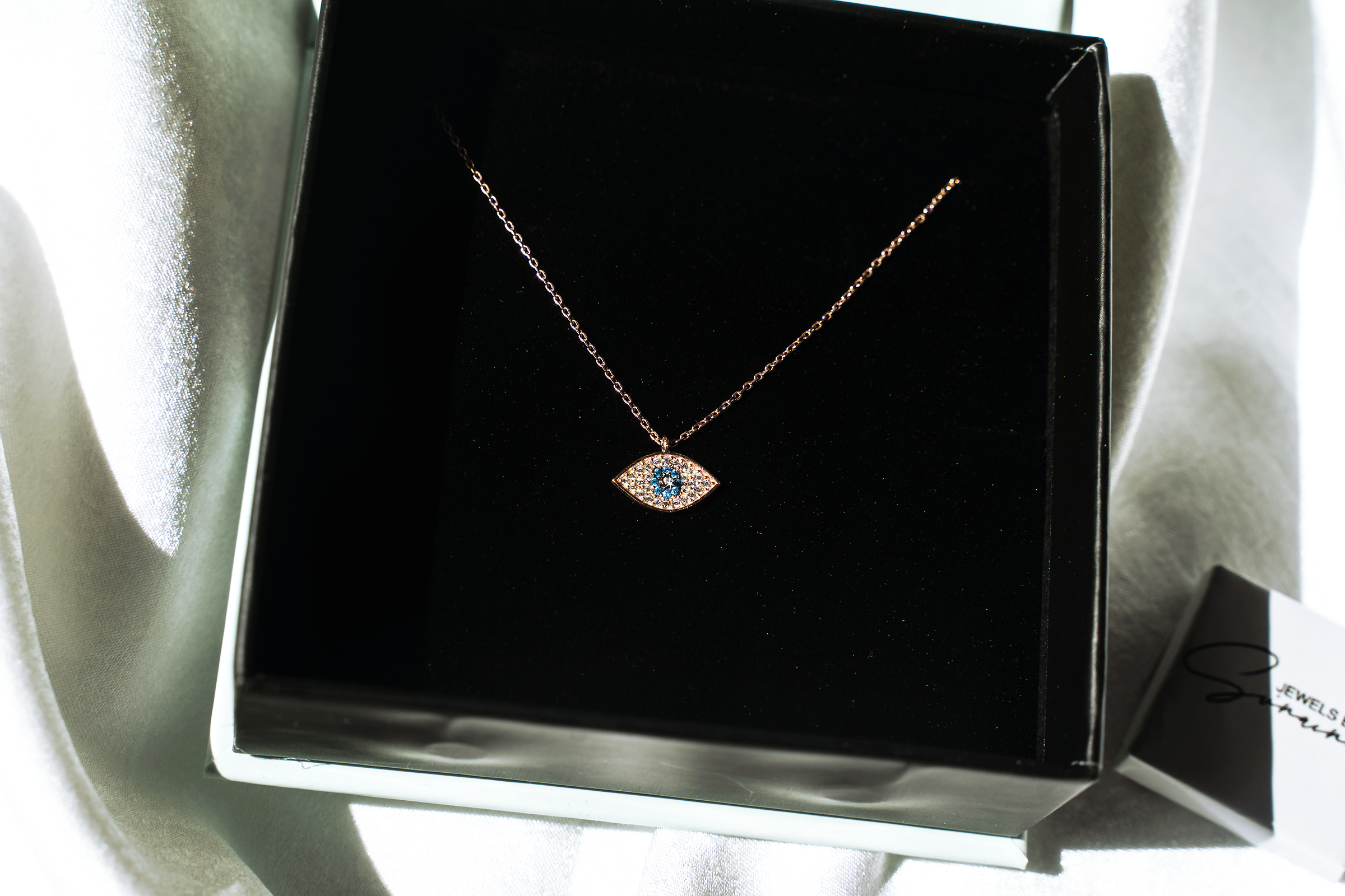 KAYLEE Necklace featuring a dainty evil eye design with rose gold plating and colorful cubic zirconias on a sterling silver chain.