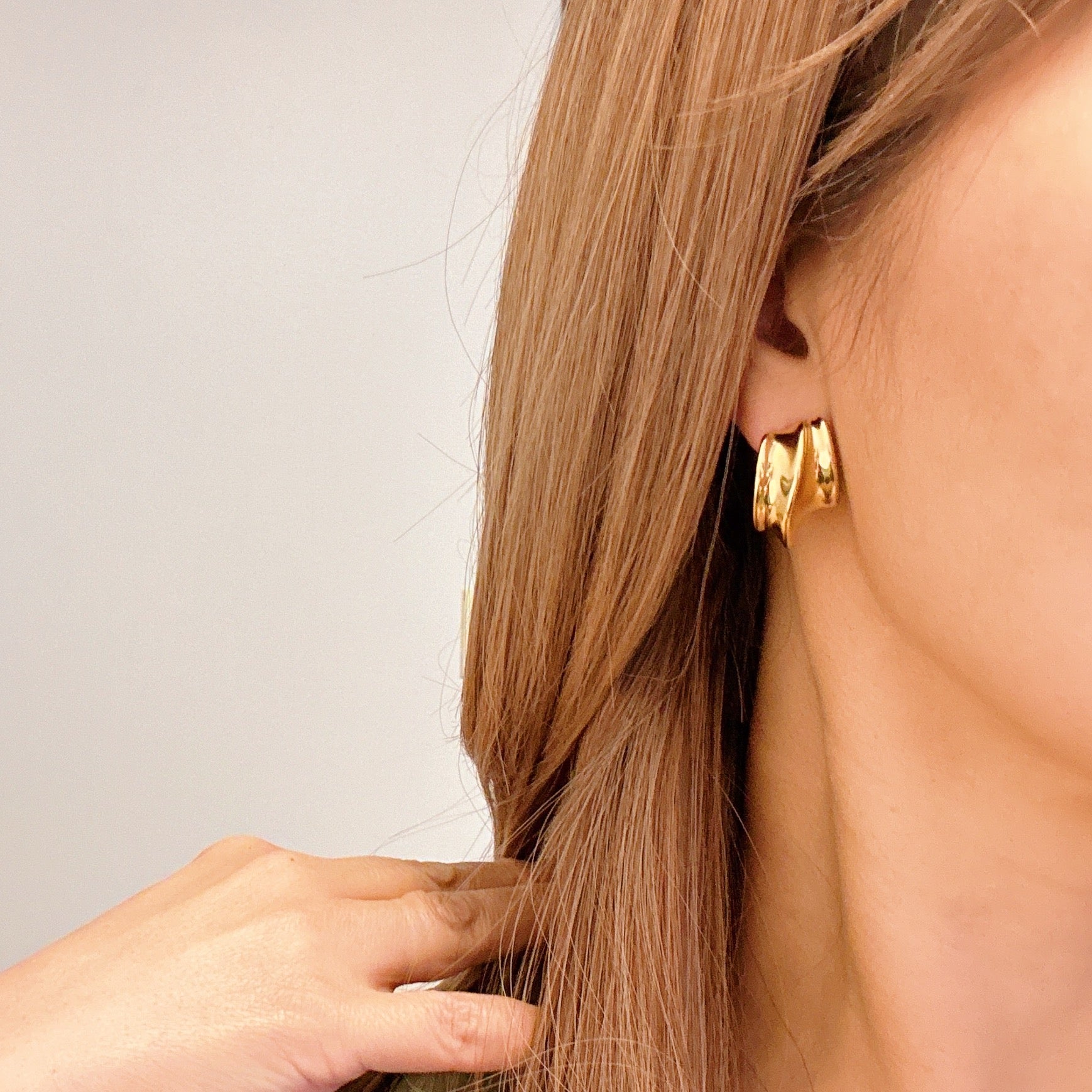 A pair of Kelly Golden Hoop Earrings made from 18k gold plated stainless steel, showcasing a modern and chic design.