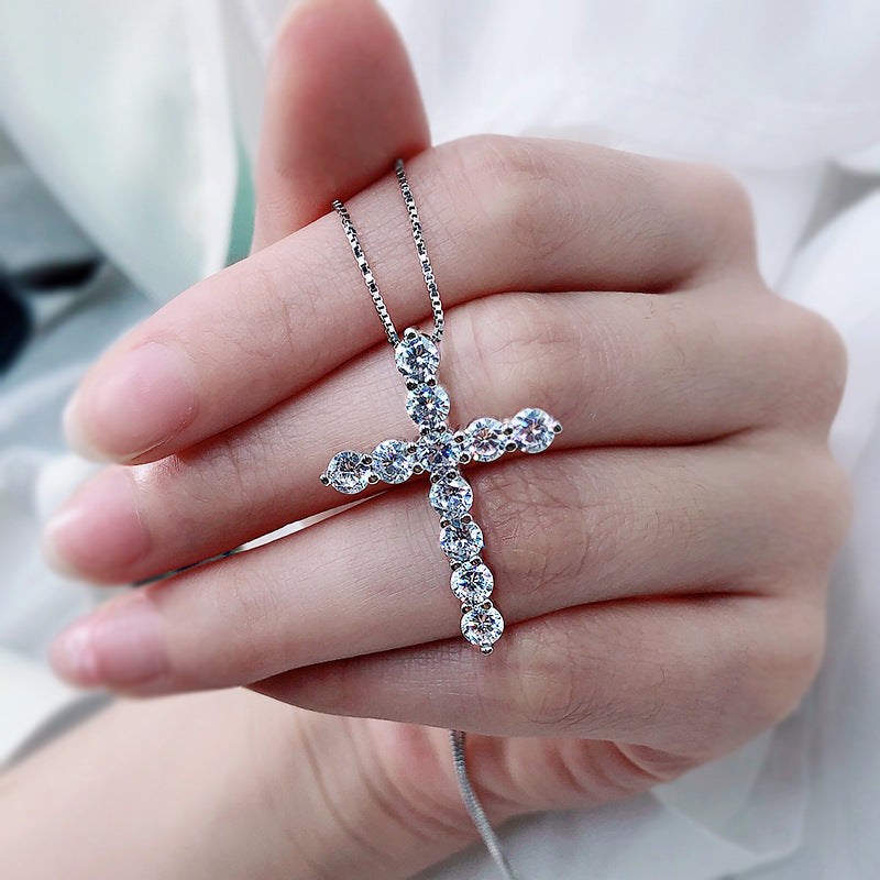 A stunning cross necklace made of 925 sterling silver, featuring a polished finish and adorned with sparkling cubic zirconia stones.