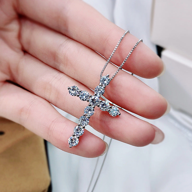 A stunning cross necklace made of 925 sterling silver, featuring a polished finish and adorned with sparkling cubic zirconia stones.