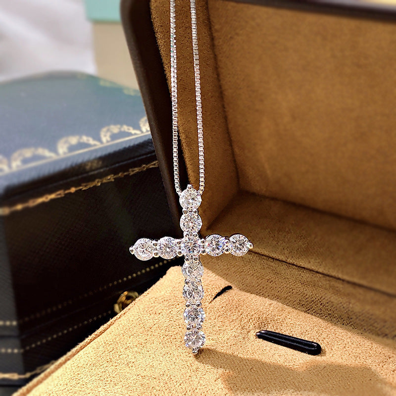 A stunning cross necklace made of 925 sterling silver, featuring a polished finish and adorned with sparkling cubic zirconia stones.