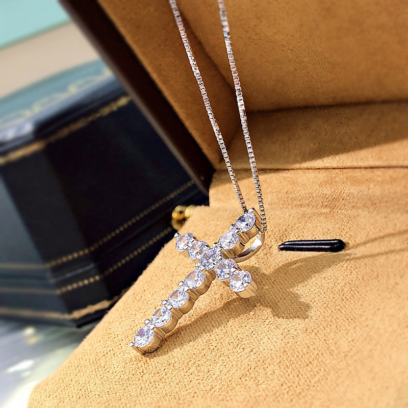 A stunning cross necklace made of 925 sterling silver, featuring a polished finish and adorned with sparkling cubic zirconia stones.