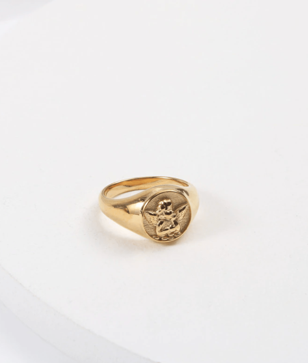 Kiki Carved Angel Baby Signet Ring showcasing a chunky gold and silver design with a carved angel motif.