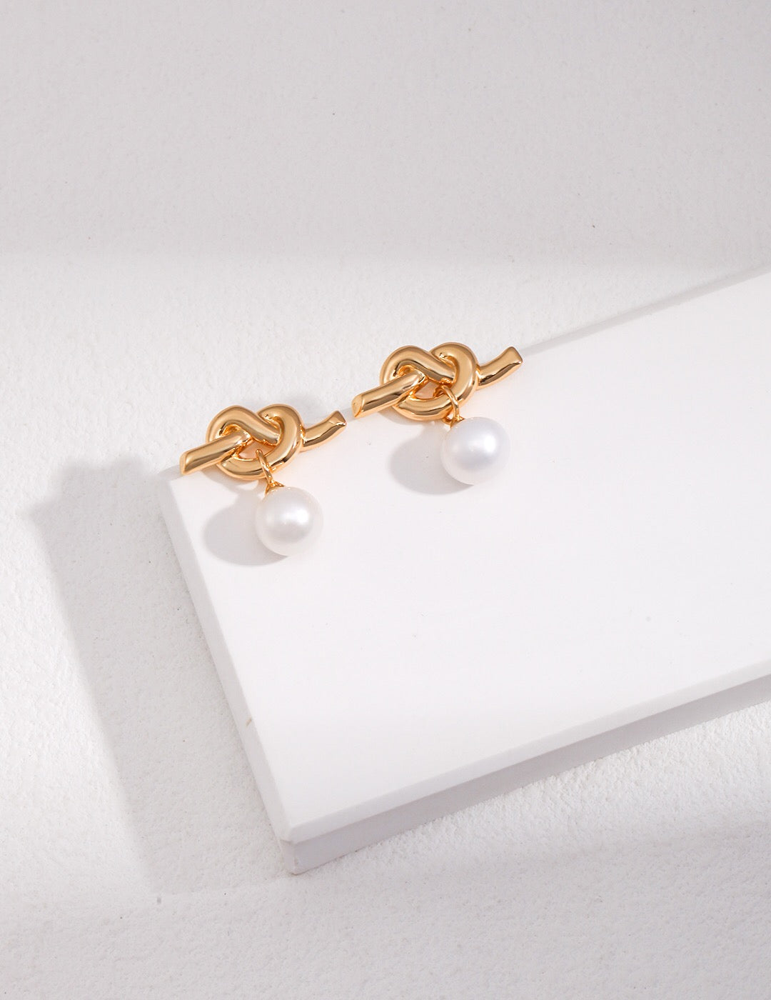 Elegant Knot Design Pearl Earrings featuring natural pearls and sterling silver, perfect for any occasion.