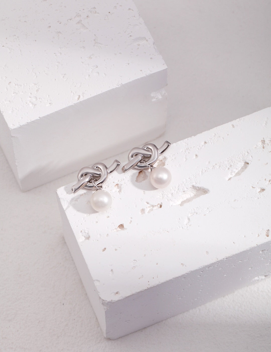 Elegant Knot Design Pearl Earrings featuring natural pearls and sterling silver, perfect for any occasion.