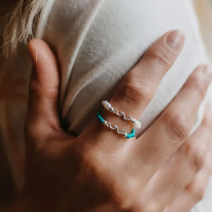 Kuta Wave Stone Stretch Ring featuring turquoise stones and a silver-plated wave charm, designed for a comfortable fit.