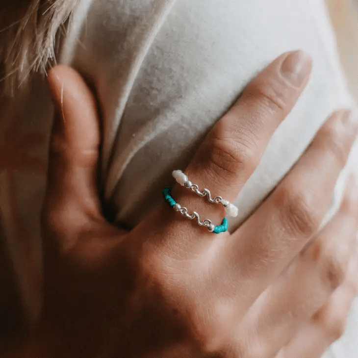 Kuta Wave Stone Stretch Ring featuring turquoise stones and a silver-plated wave charm, designed for a comfortable fit.