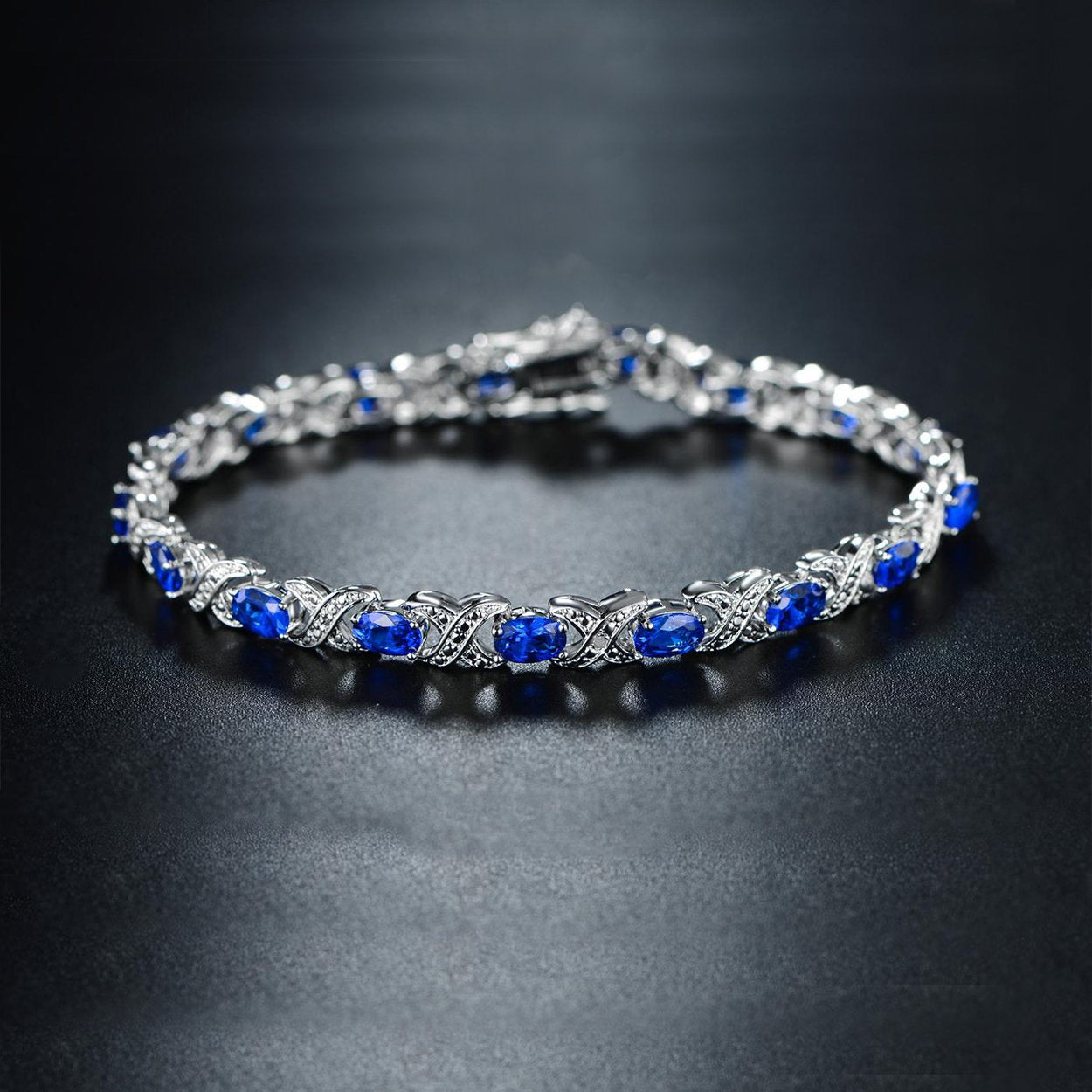 Lab-Created Blue Sapphire and Diamond Accent Tennis Bracelet featuring round stones and 18k white gold plating, elegantly designed for any occasion.