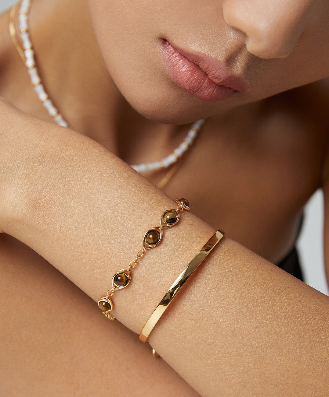 Handmade adjustable bracelet featuring Lapis Lazuli and Tigers Eye stones with gold vermeil accents, elegantly displayed on a soft surface.